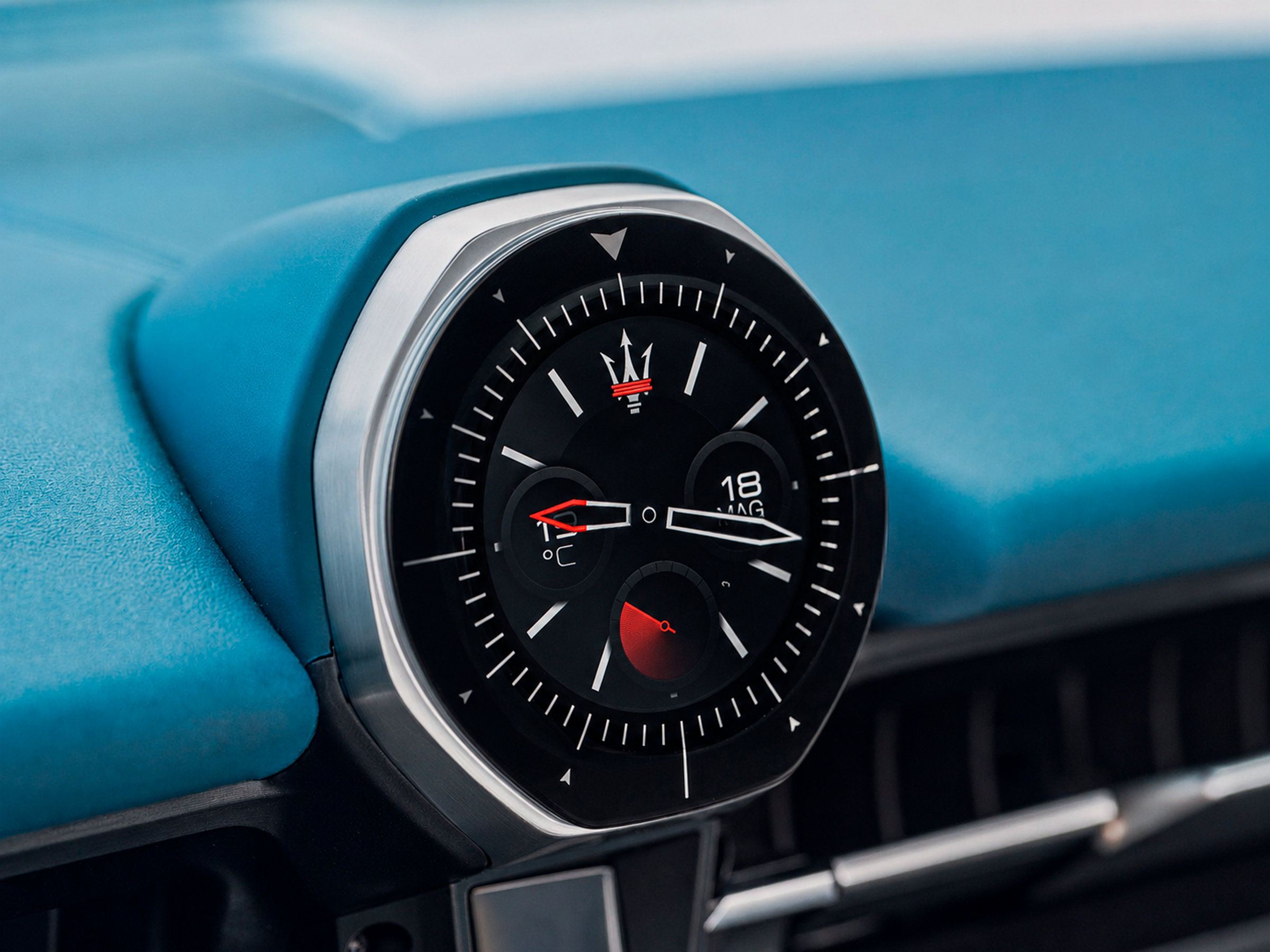 Close-up of a car dashboard clock with a blue background, showing the time as 1:43, and a temperature gauge at 10°C.