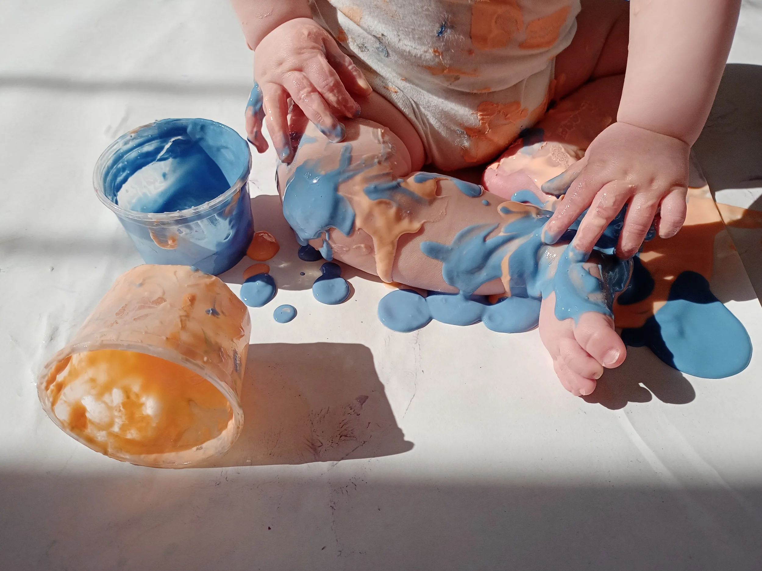 BAmbino del nido che gioca con colori