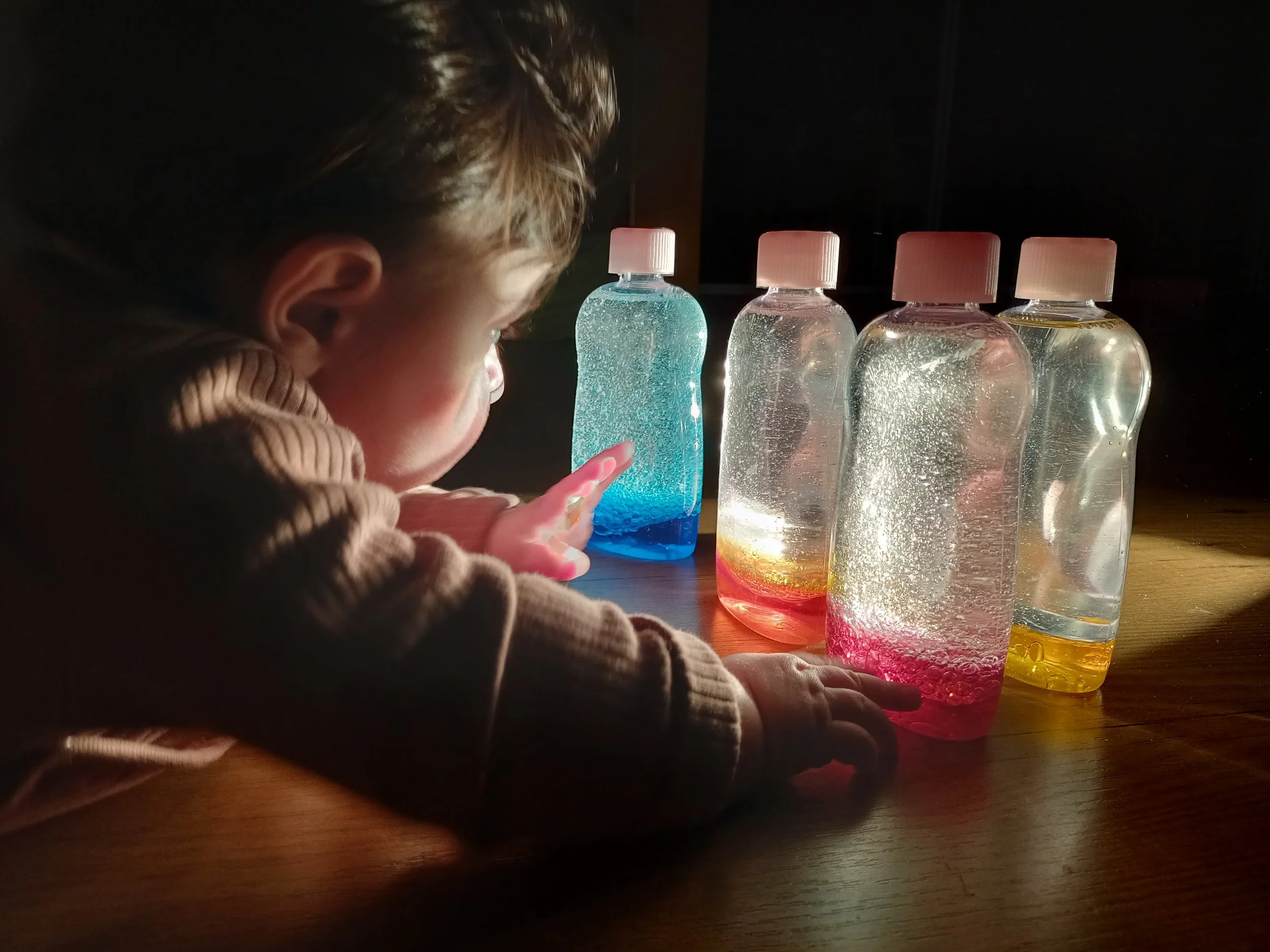 bambino che gioca con barattoli e luce