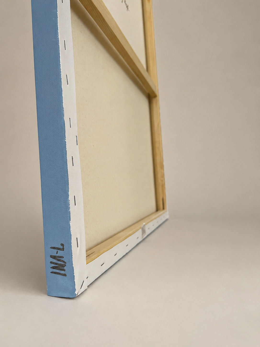 Side view of a 3.5 cm deep stretched canvas with a light painted edge, the artist’s INA-L signature and the stapled reverse visible.