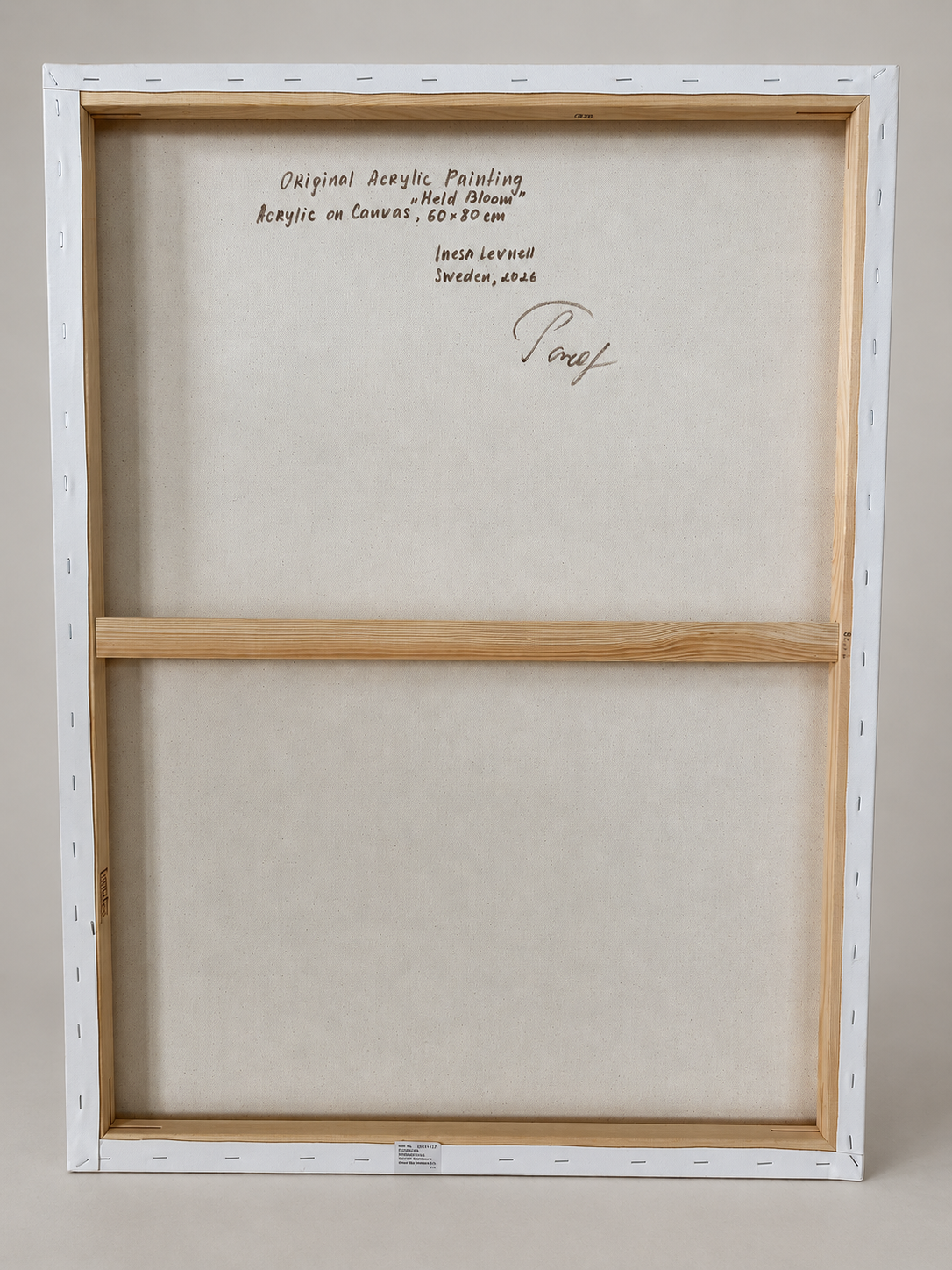 Back view of Held Bloom by Inesa Levnell, showing the stretched canvas, wooden stretcher bars and handwritten artwork information on the reverse.