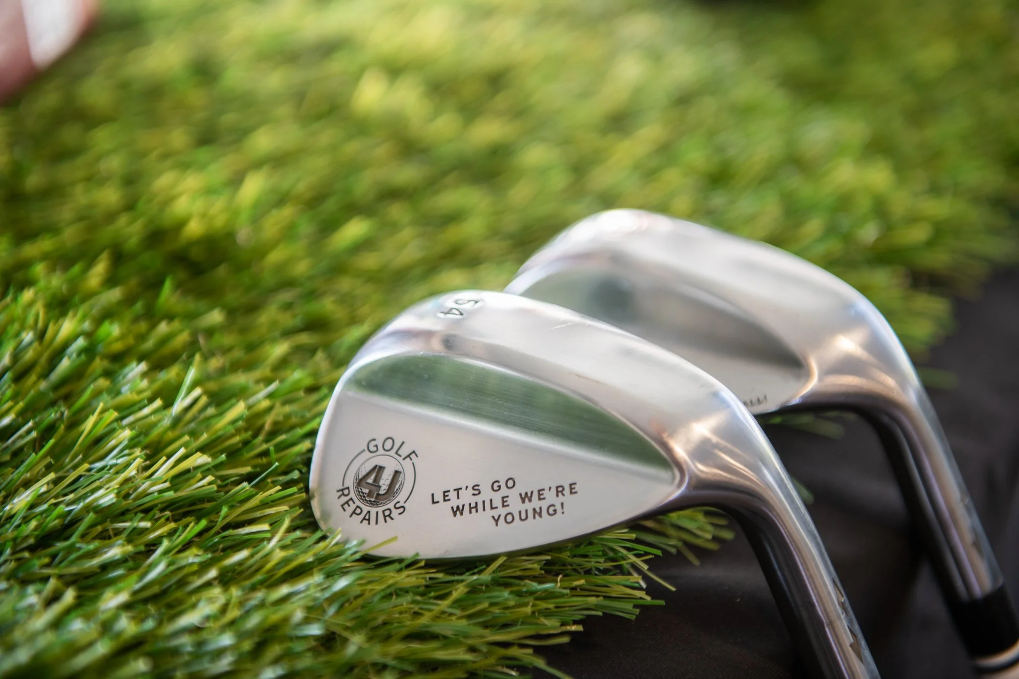 Close-up of golf clubs lying on the grass on a golf course.