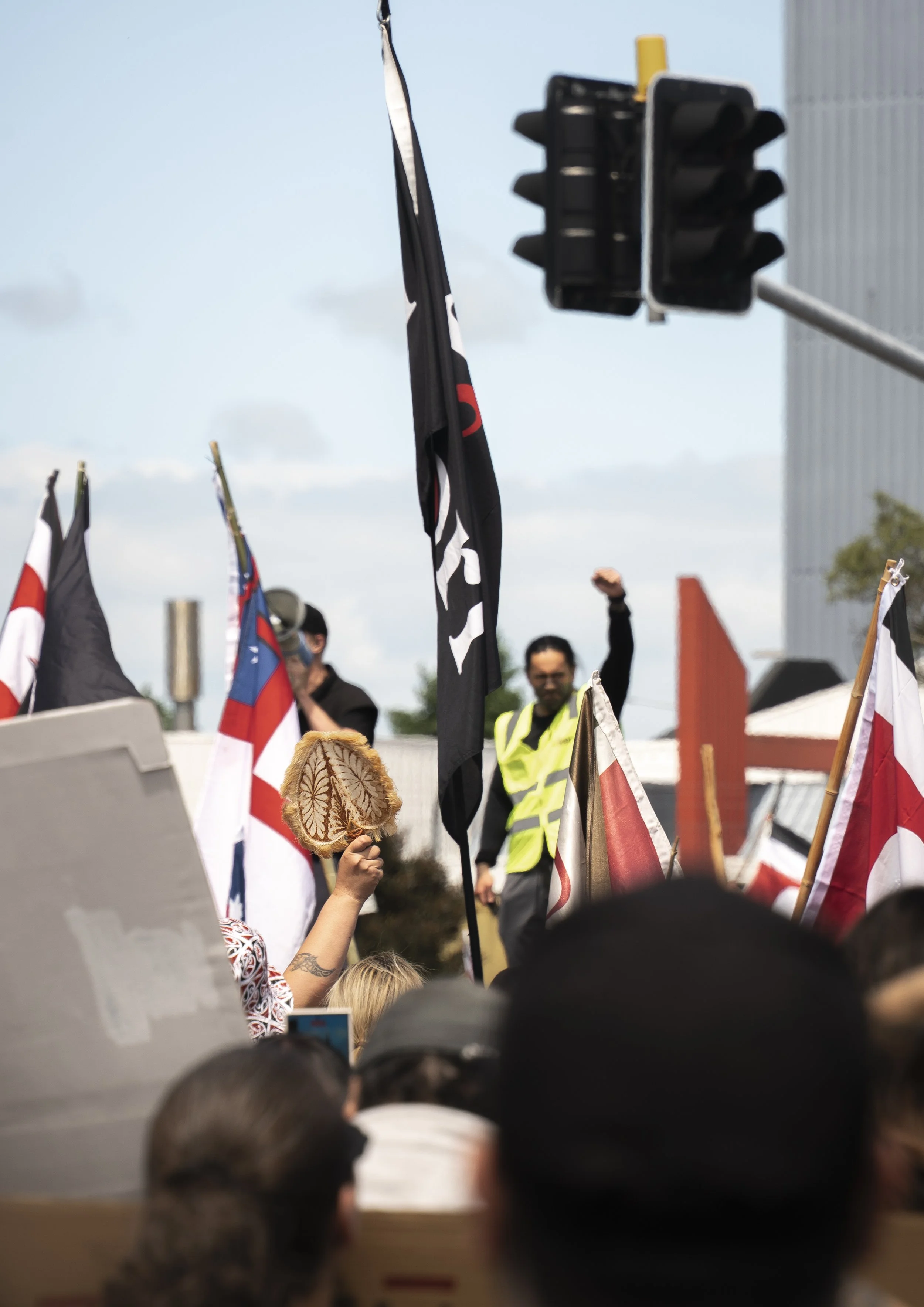 An example of Documentary Photography of a speaker and participant holding up fists at the Hikoi across New Zealand