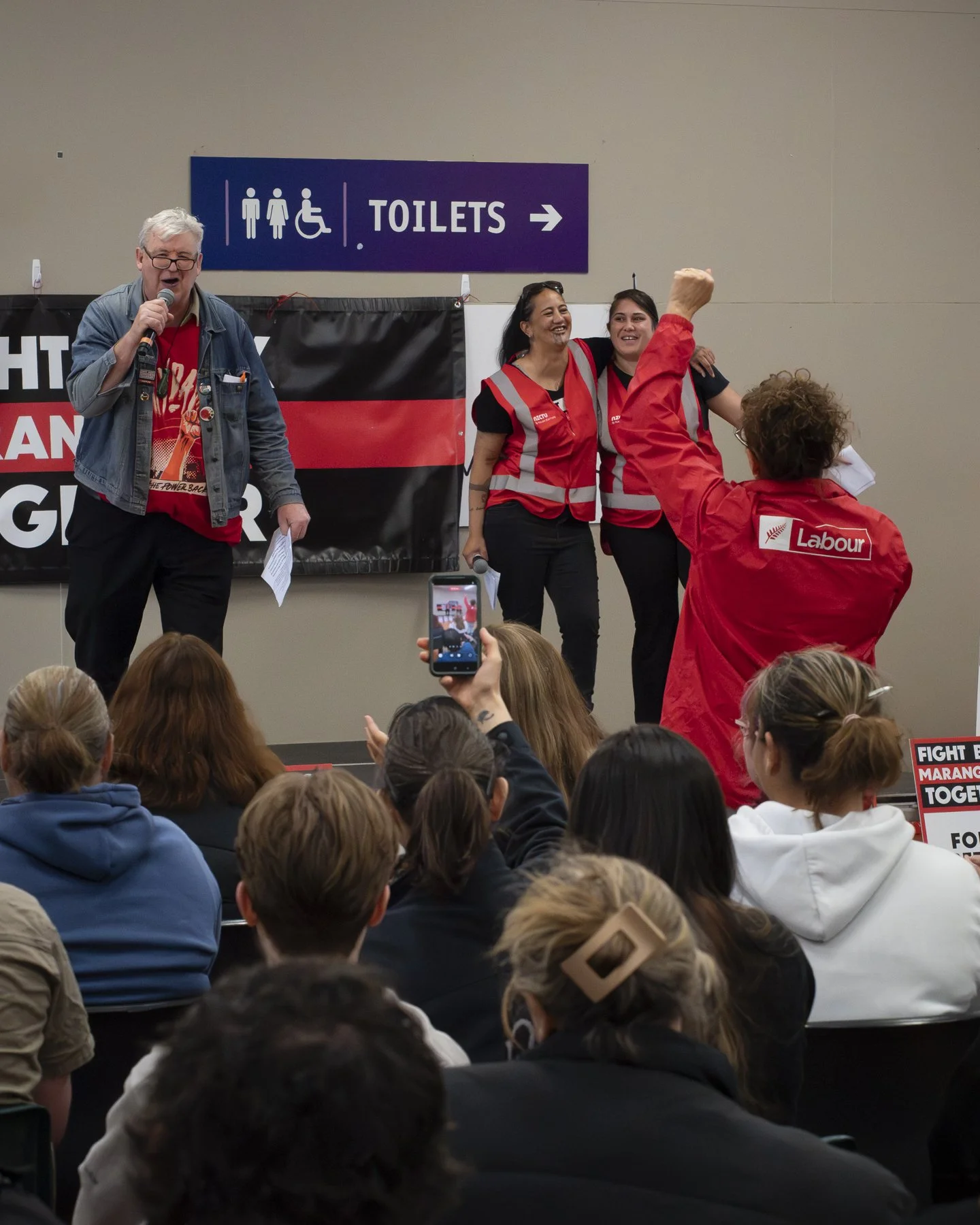 An example of Documentary Photography of a Union leader and speaker interacting with an audience member at the Palmerston North Mayday event