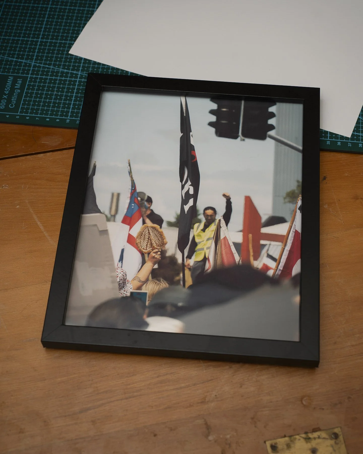 Photographic framed print of a speaker and participant holding up fists at the Hikoi across New Zealand