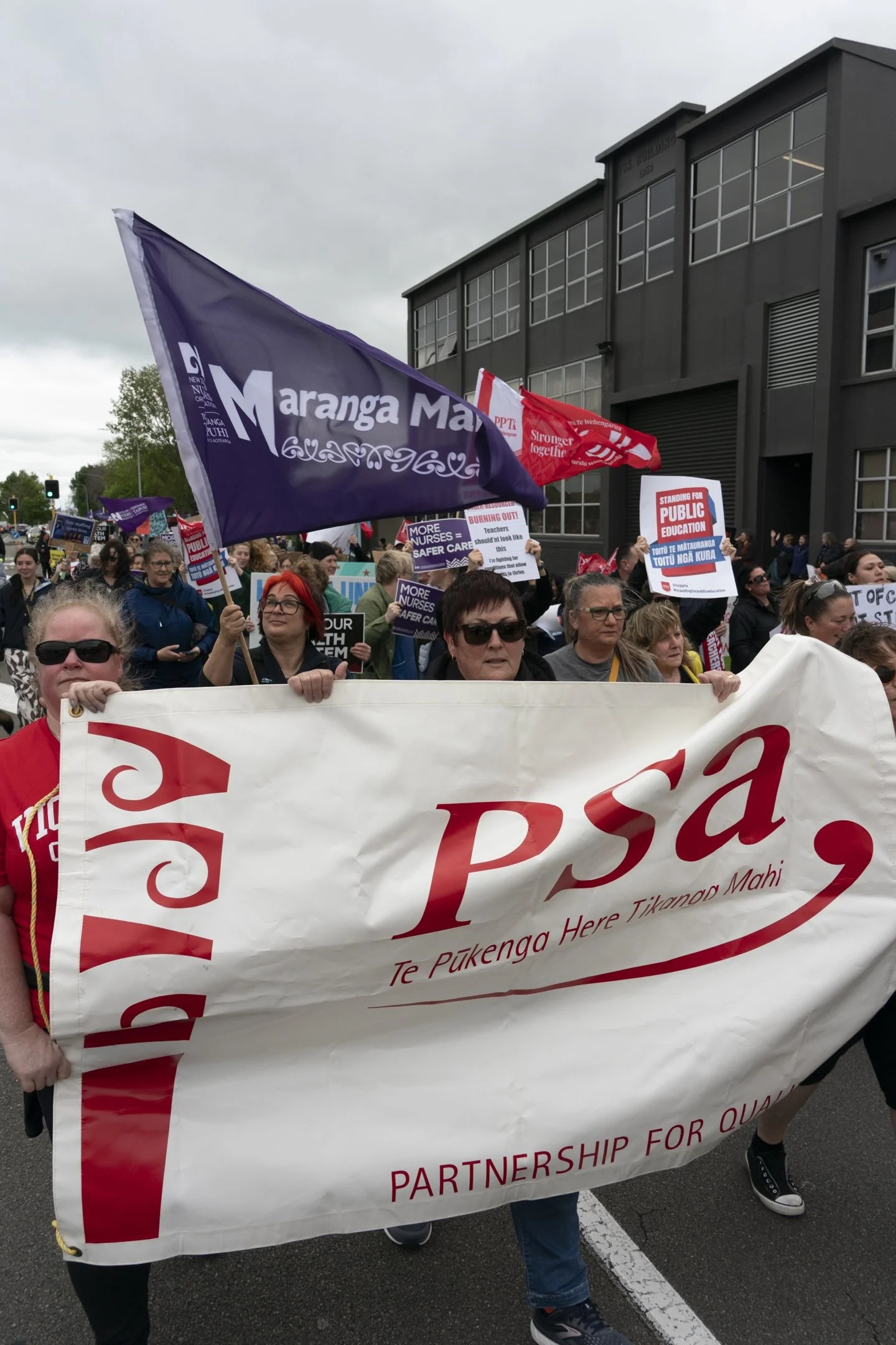 An example of Documentary Photography of Union Members marching with flags and banners towards the Palmerston North Square