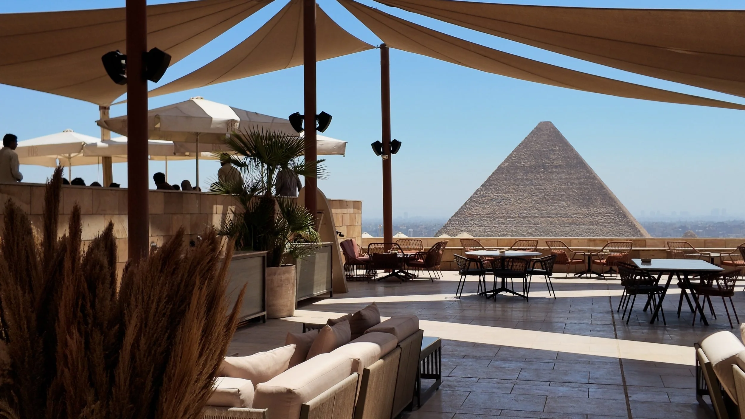 A quiet outdoor dining terrace overlooking the Giza Pyramids in Egypt, reflecting Hayah Reserve's perspective on private luxury travel.