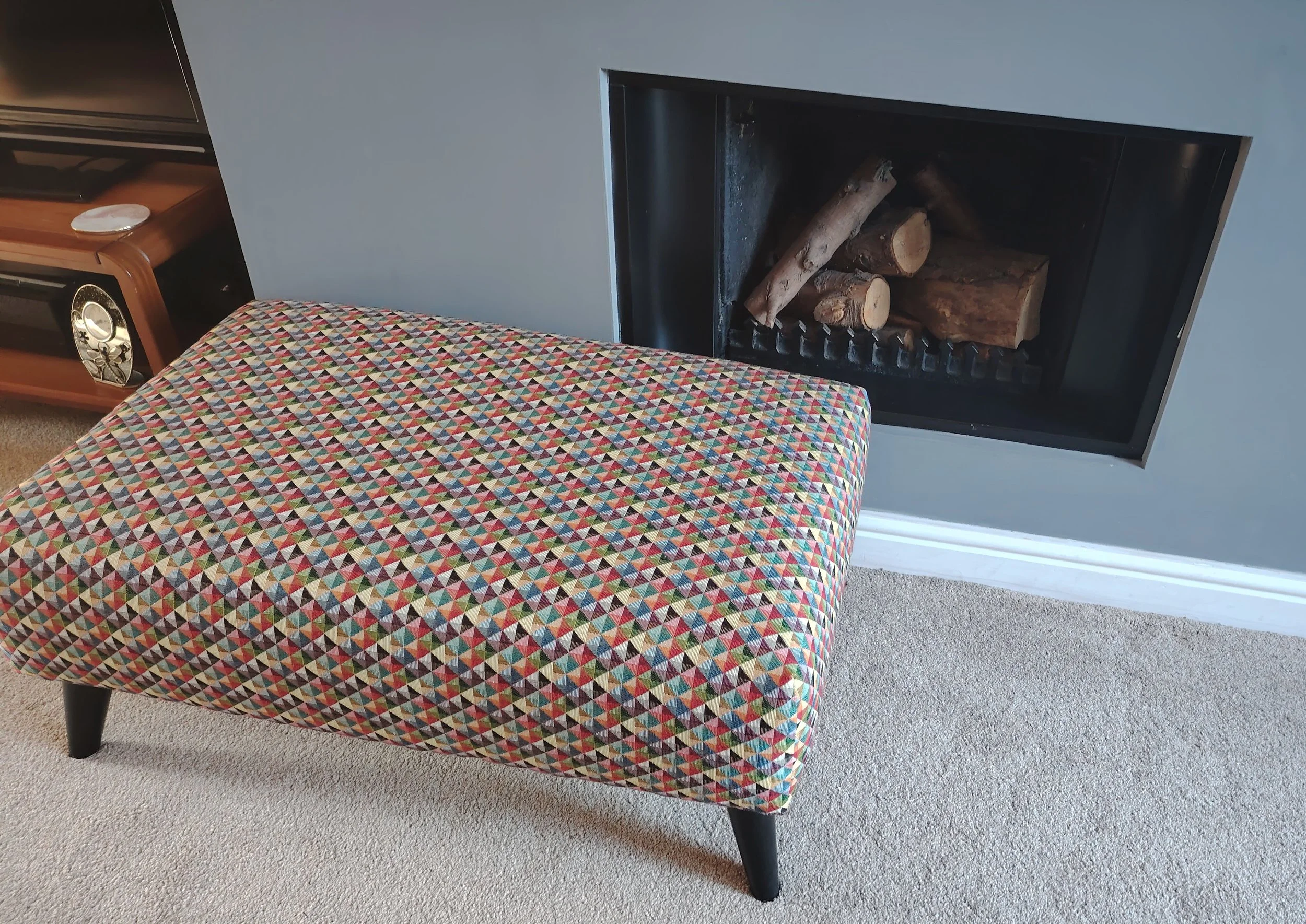 Rectangular footstool with multi coloured geometric fabric 
