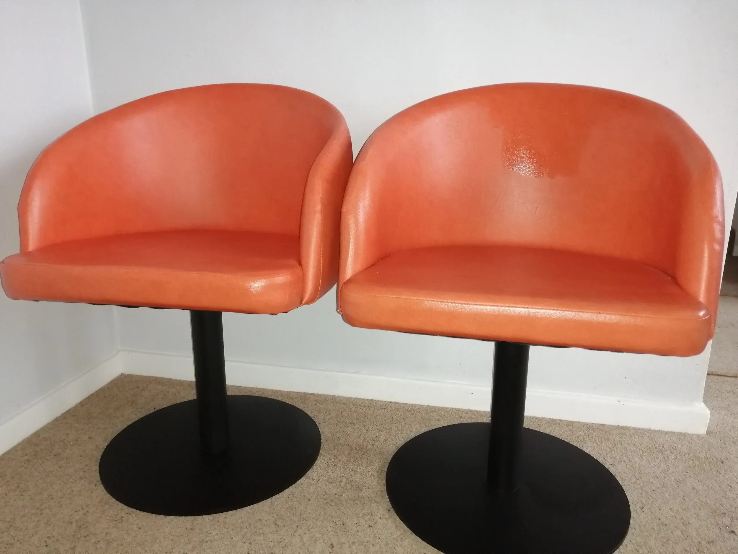 orange vinyl tub chairs with black pedestal