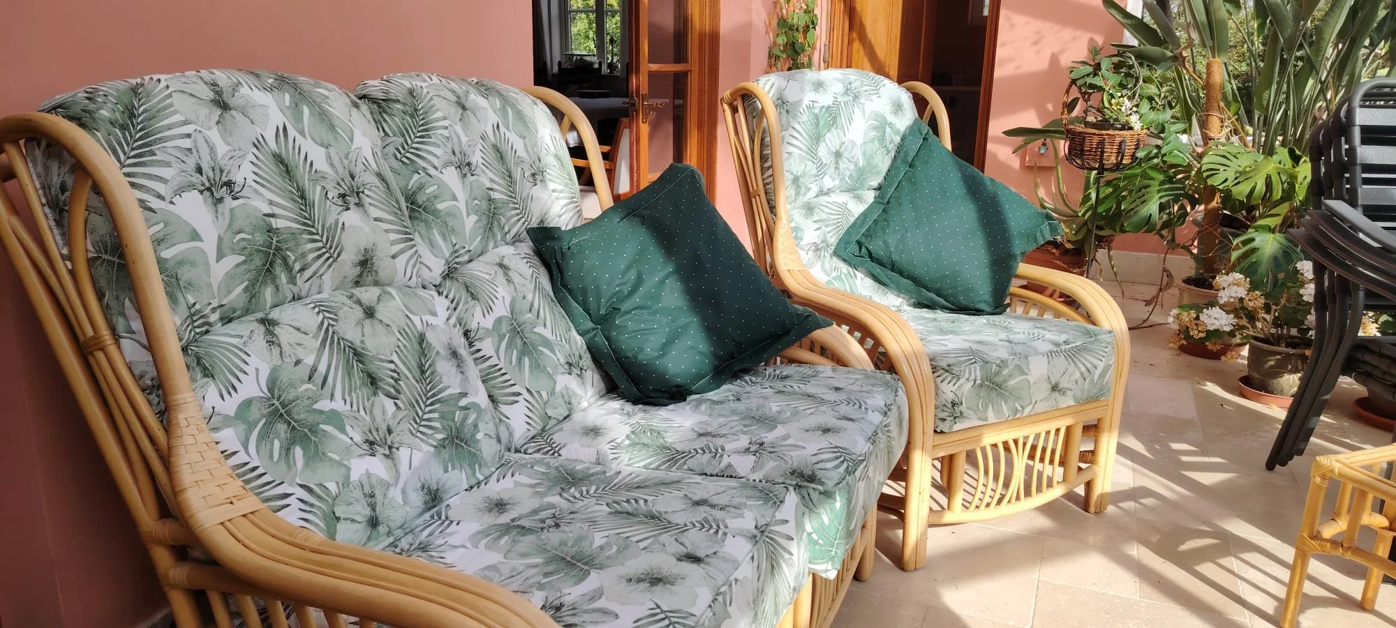 Cane garden furniture with green and white floral covers