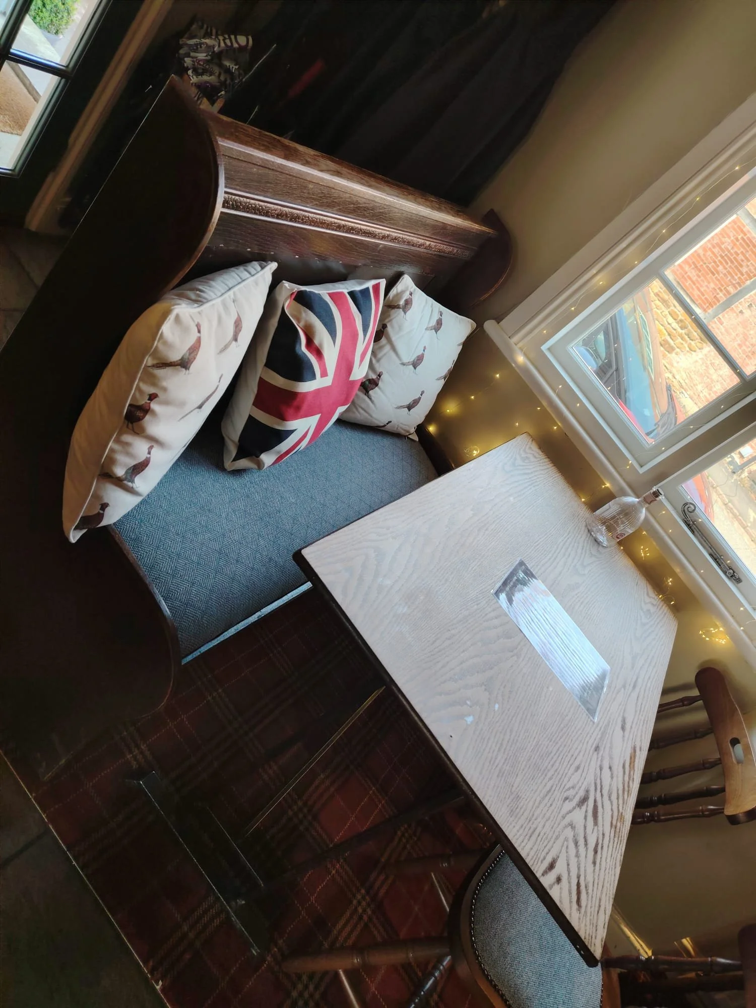 upholstery pew seat with cushions and wooden table in a bar