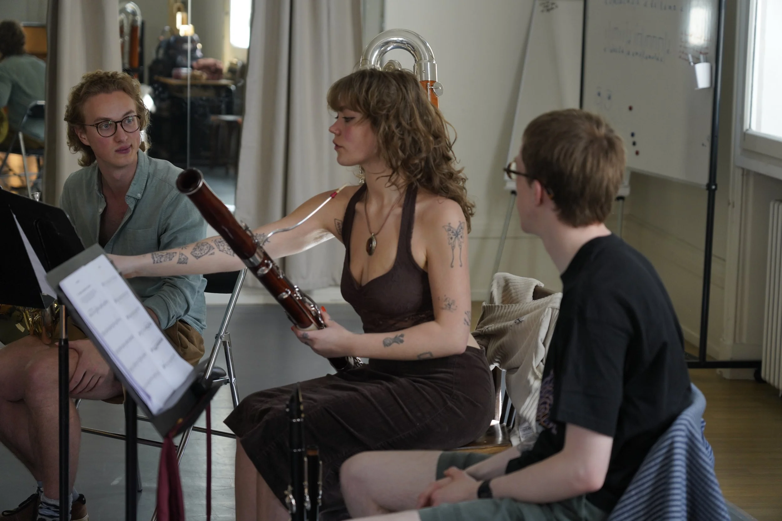 Three young musicians in a music rehearsal room.