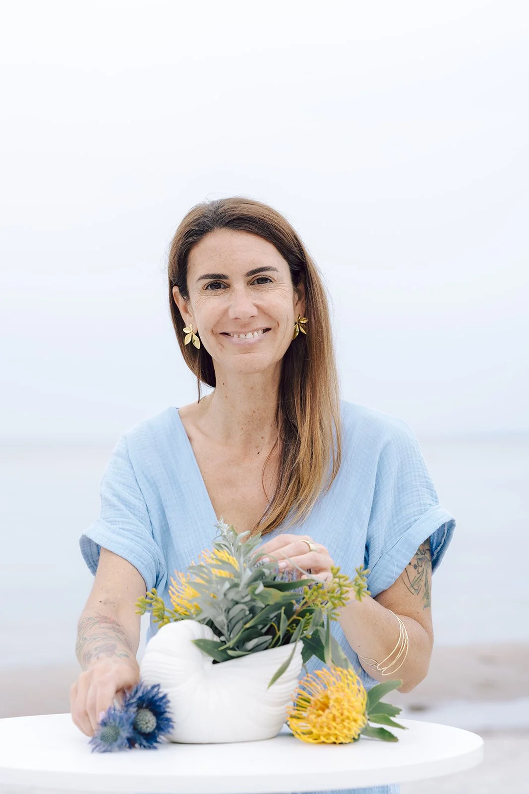 Hochzeitsplanerin Carla Sousa mit Blumen am Strand