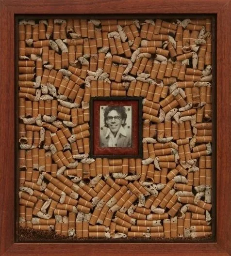 Portrait of Joe, by Joe Brainard: A framed collection of cigarette butts and a small black-and-white photo of a smiling Joe with glasses at the center.