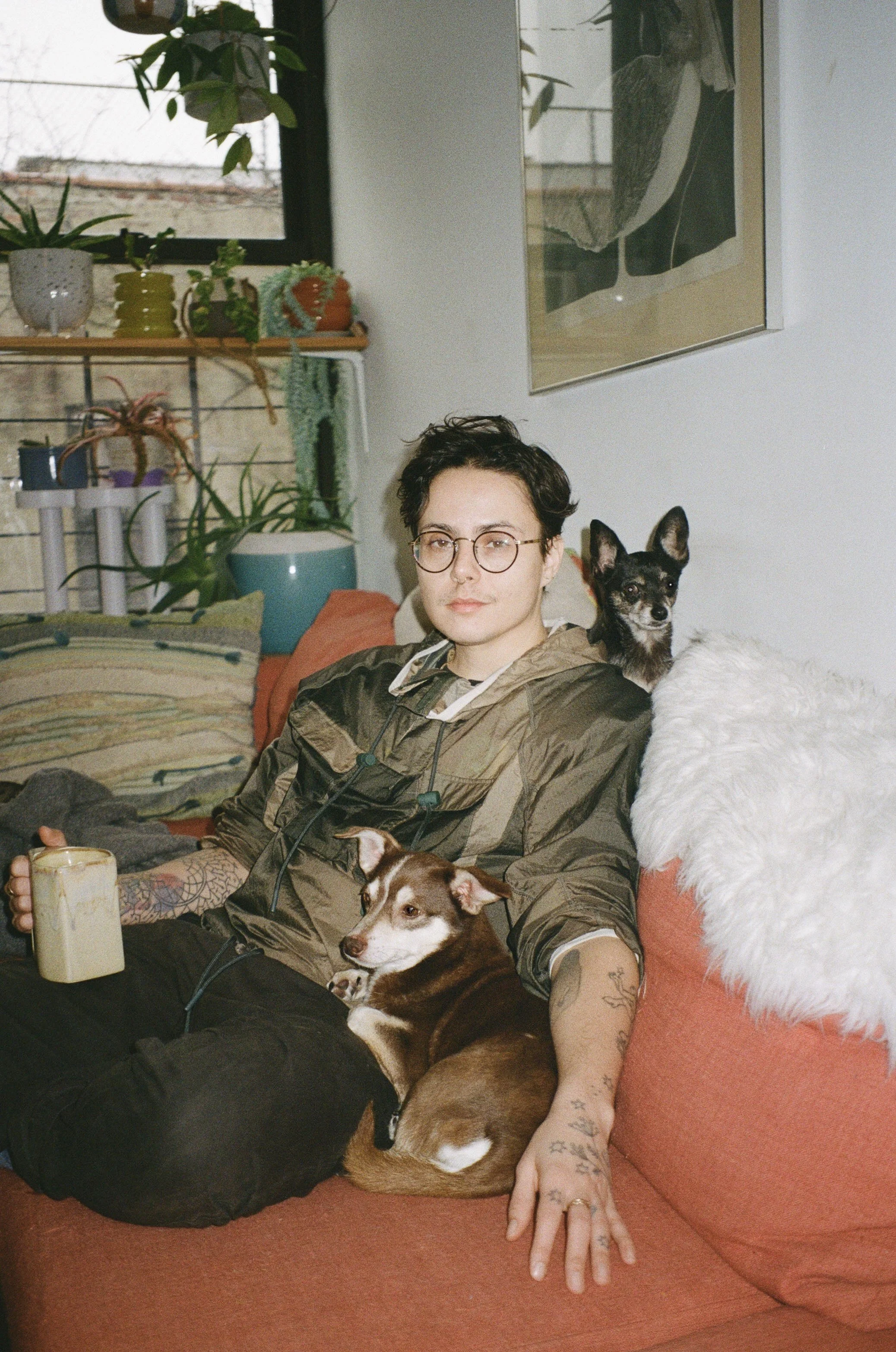 author photo: charles is sitting on a red couch with two dogs