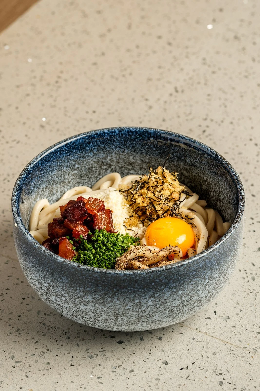 Carbonara (brothless) |
house udon + guanciale + *egg yolks + romano cheese + nori crunch + fresh cracked black pepper + chives
$18.00