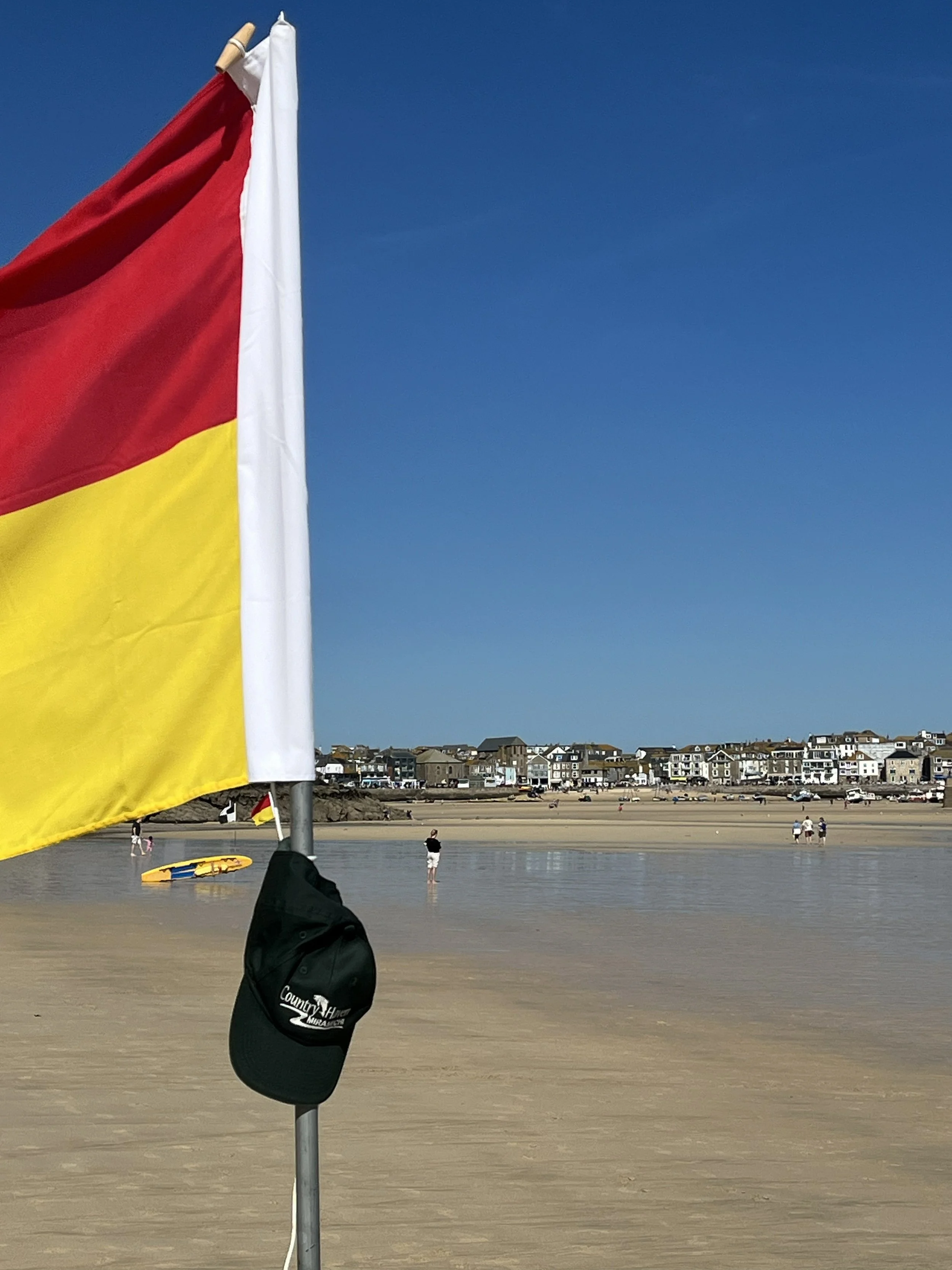 Hat is on the beach in Cornwall, UK