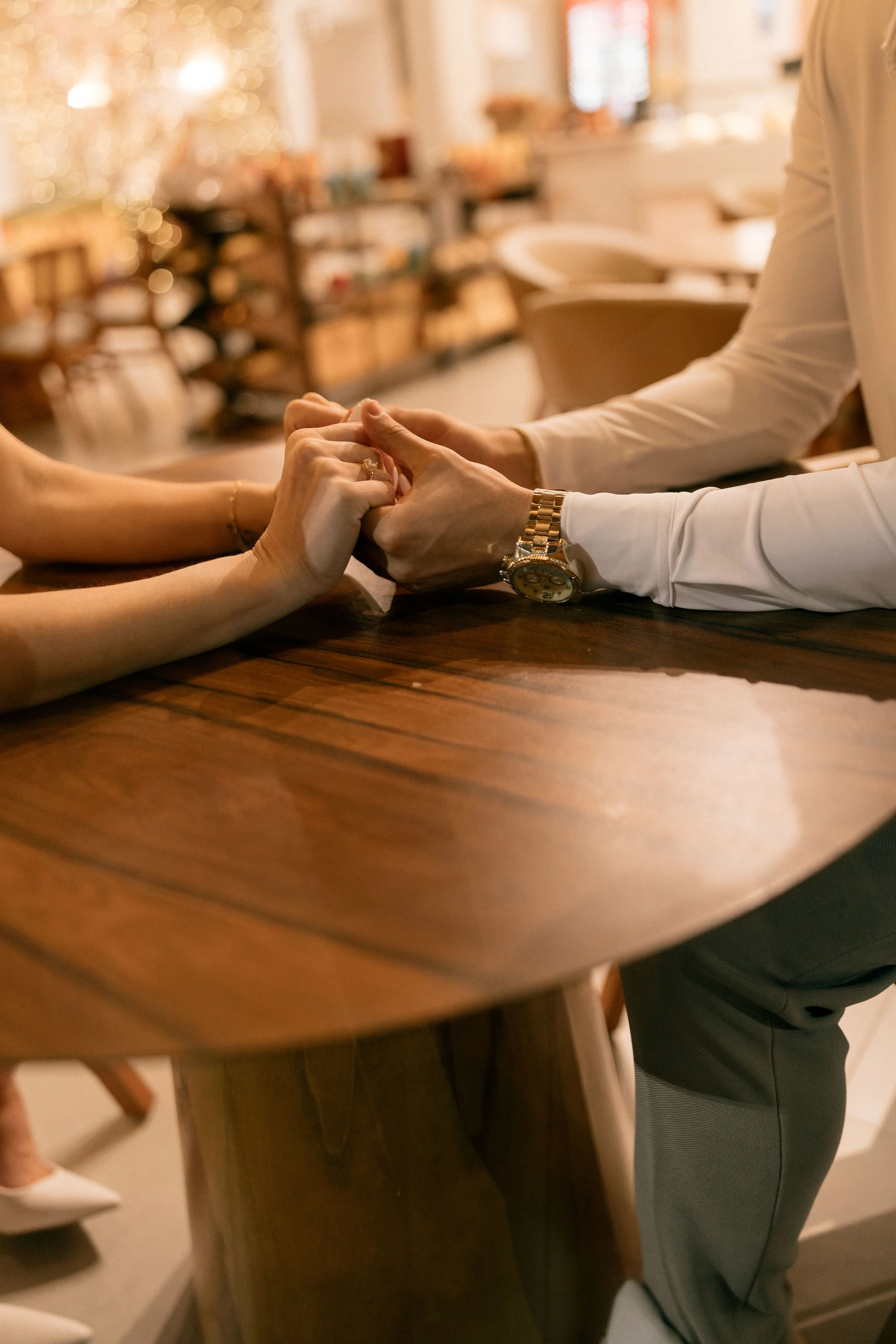 Paar hält Hände am Tisch – intensive Paartherapie in Heidelberg