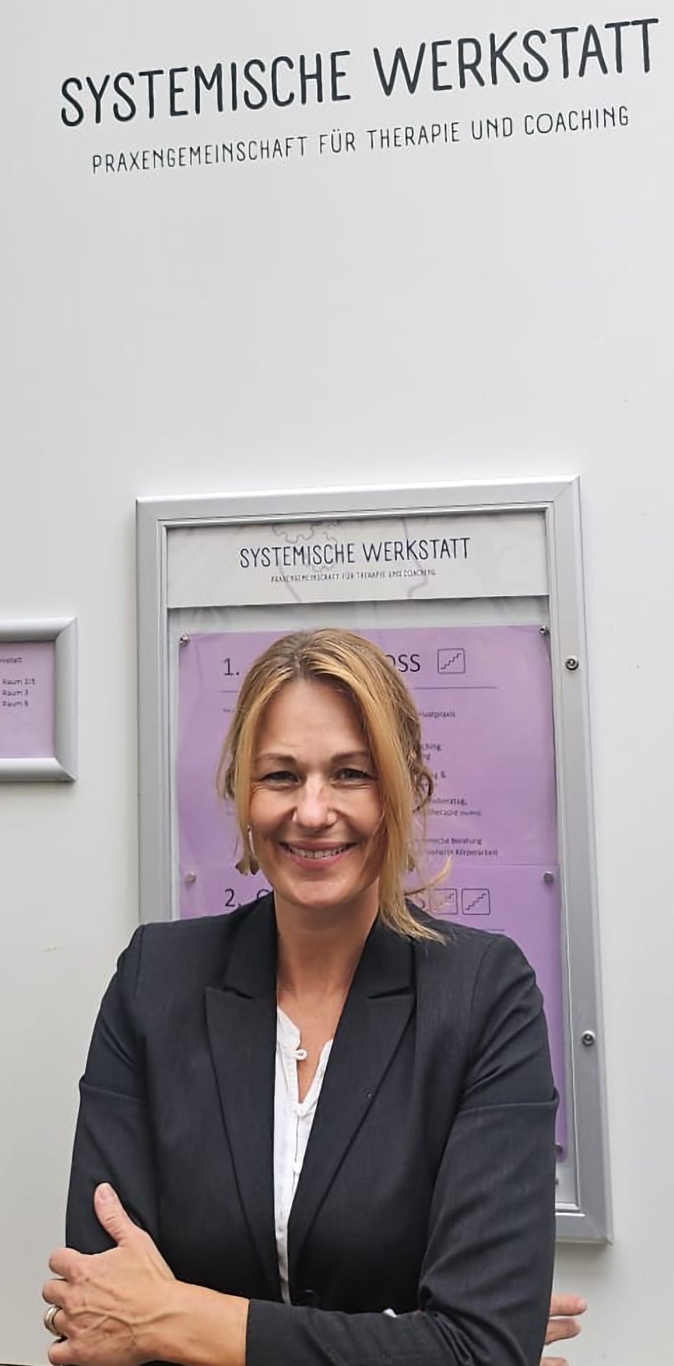 Julia_Vettermann steht vor ihrem Praxisschild in der Märzgasse