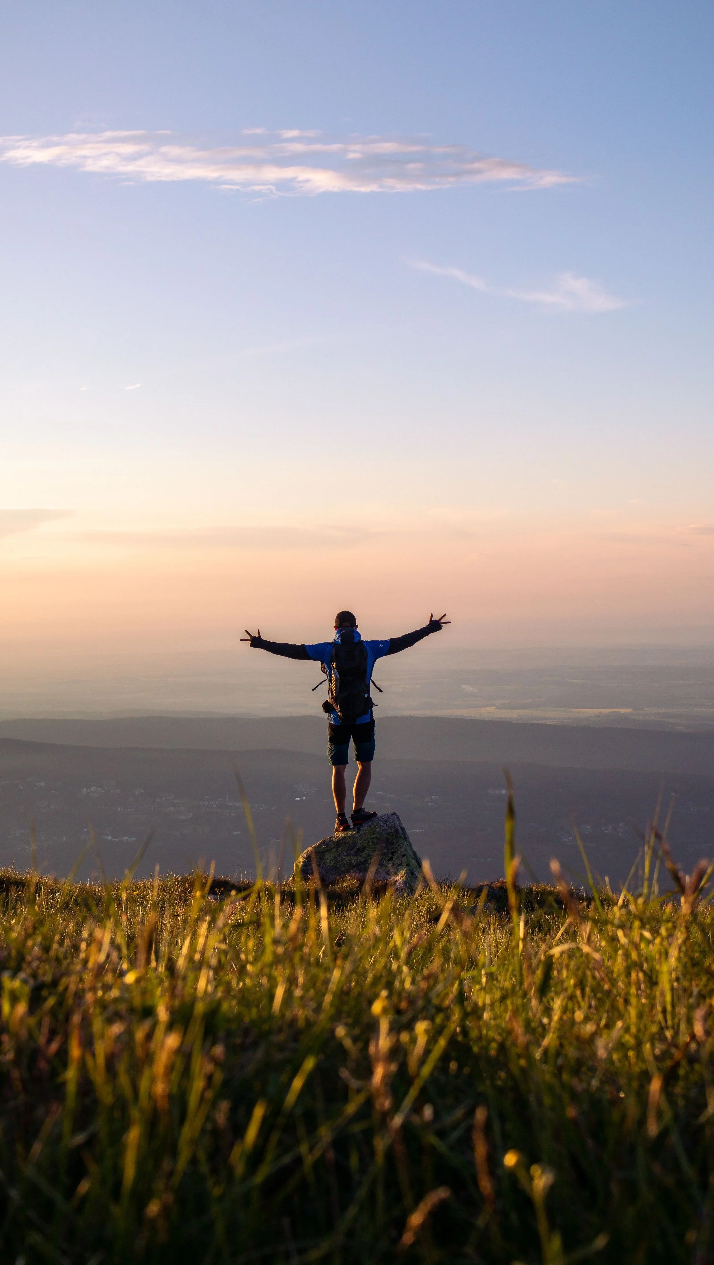 Person mit ausgebreiteten Armen auf einem Feld bei Sonnenuntergang – Singlecoaching „Innerer Kompass"