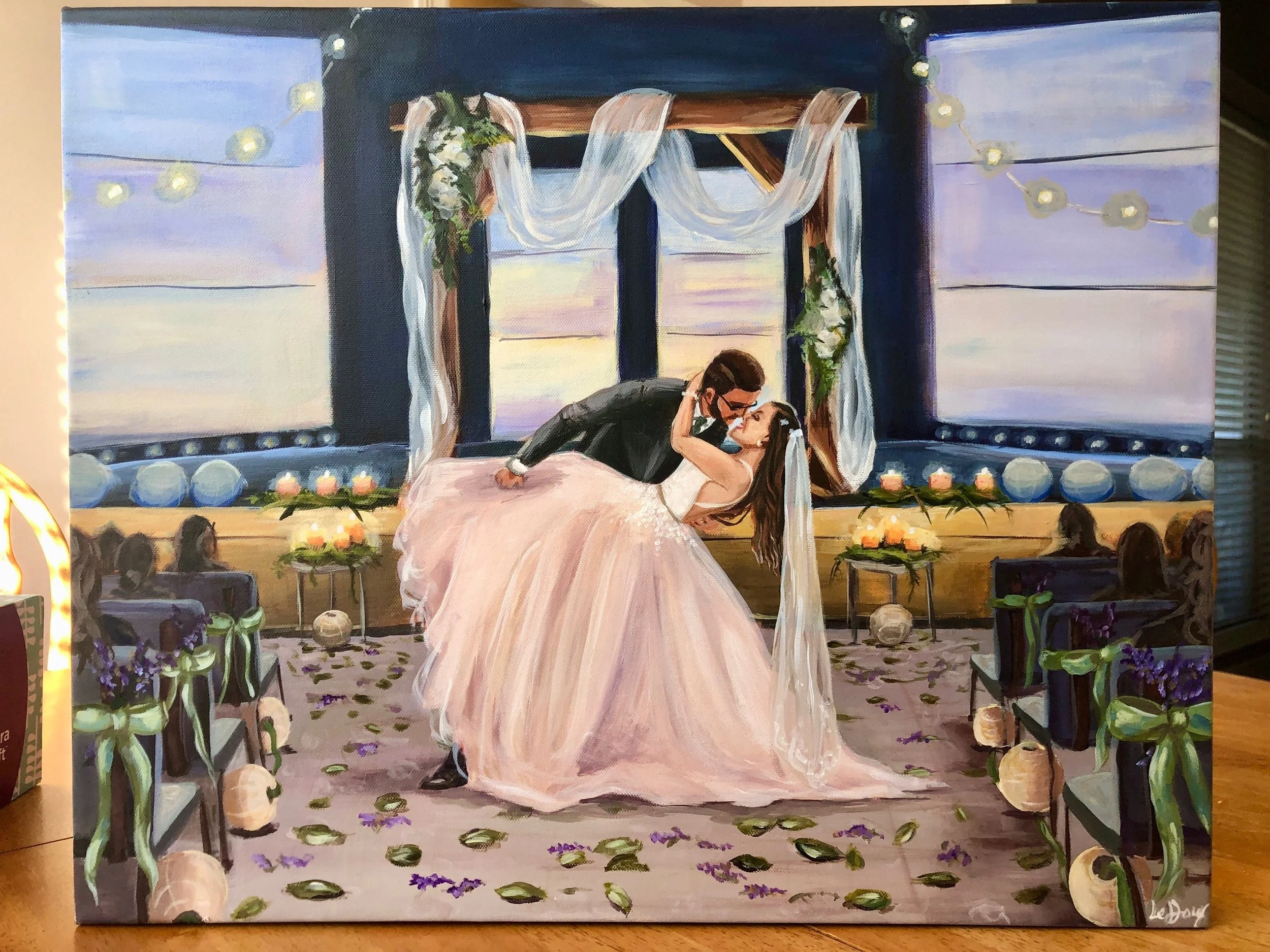 Painting of a man and woman in wedding attire sharing a kiss beneath a decorated arch with a sunset in the background.