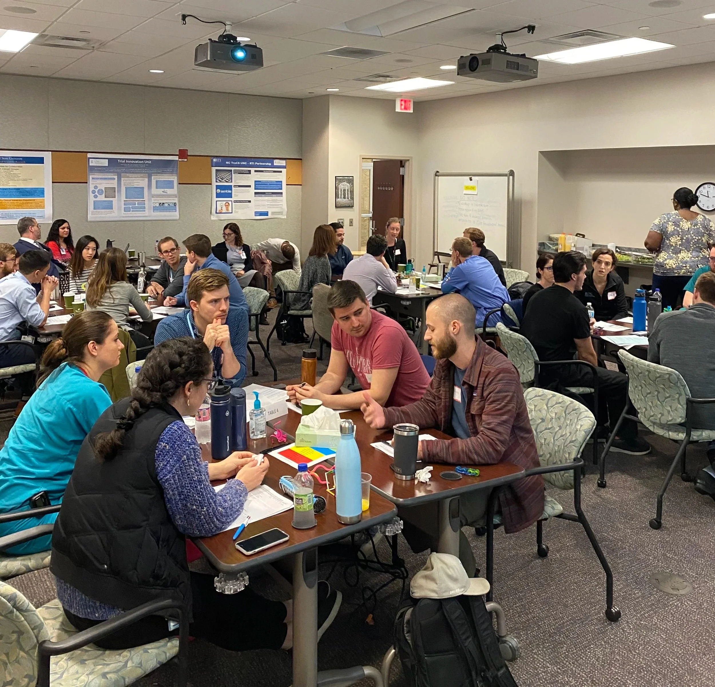 Groups sharing practice observations with peers in a classroom setting.