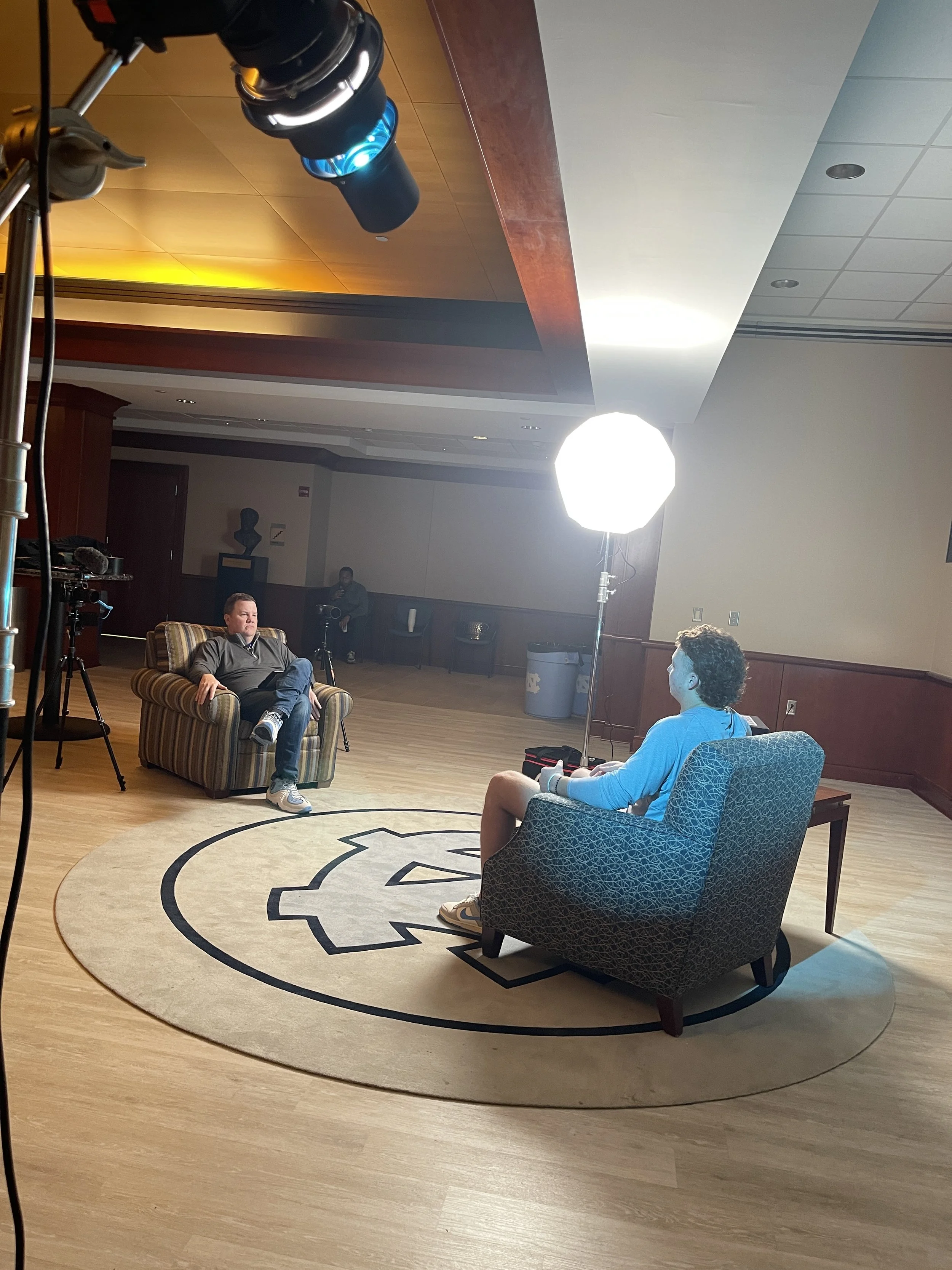 Joey Powell interviewing a professional athlete in a casual conversation.
