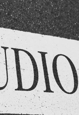 Close-up of a printed paper with the partial word 'DI0' visible, placed on a textured dark surface.