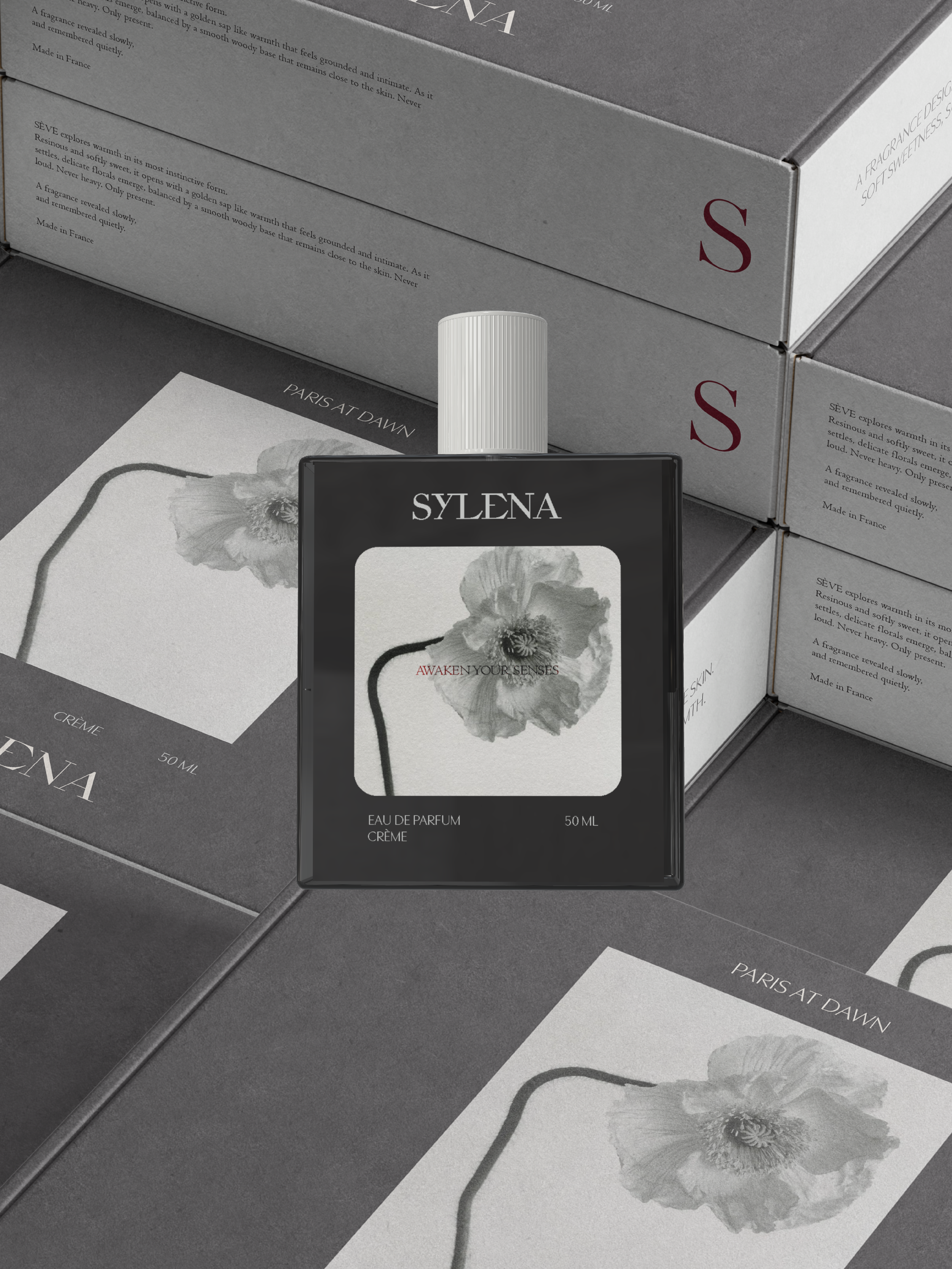 Sylena eau de parfum bottle with a poppy label, resting on its printed cartons