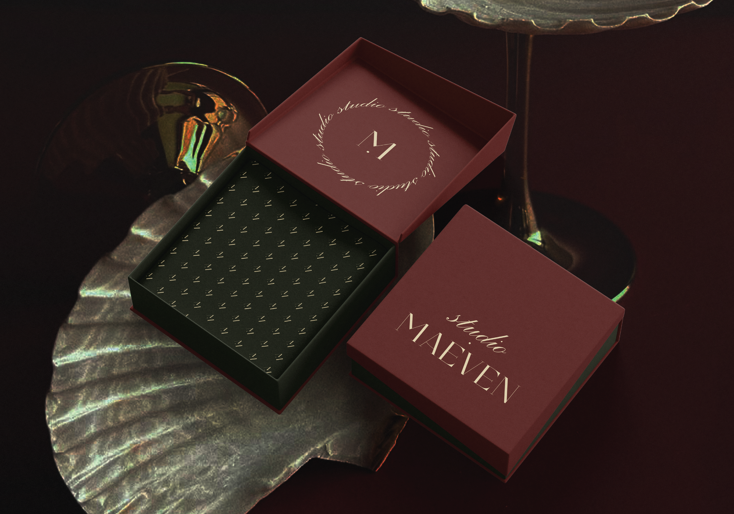 Open jewelry or jewelry box with the text 'studio 34 handcrafted' and 'MADE IN' on the lid, placed on a reflective surface with light reflections creating a pattern.