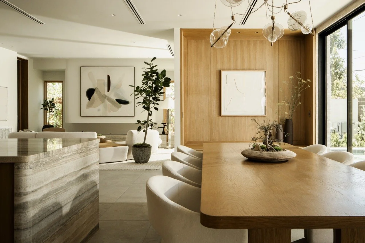 Modern open-concept living and dining area with wooden accents, abstract artwork, indoor plants, and natural light.