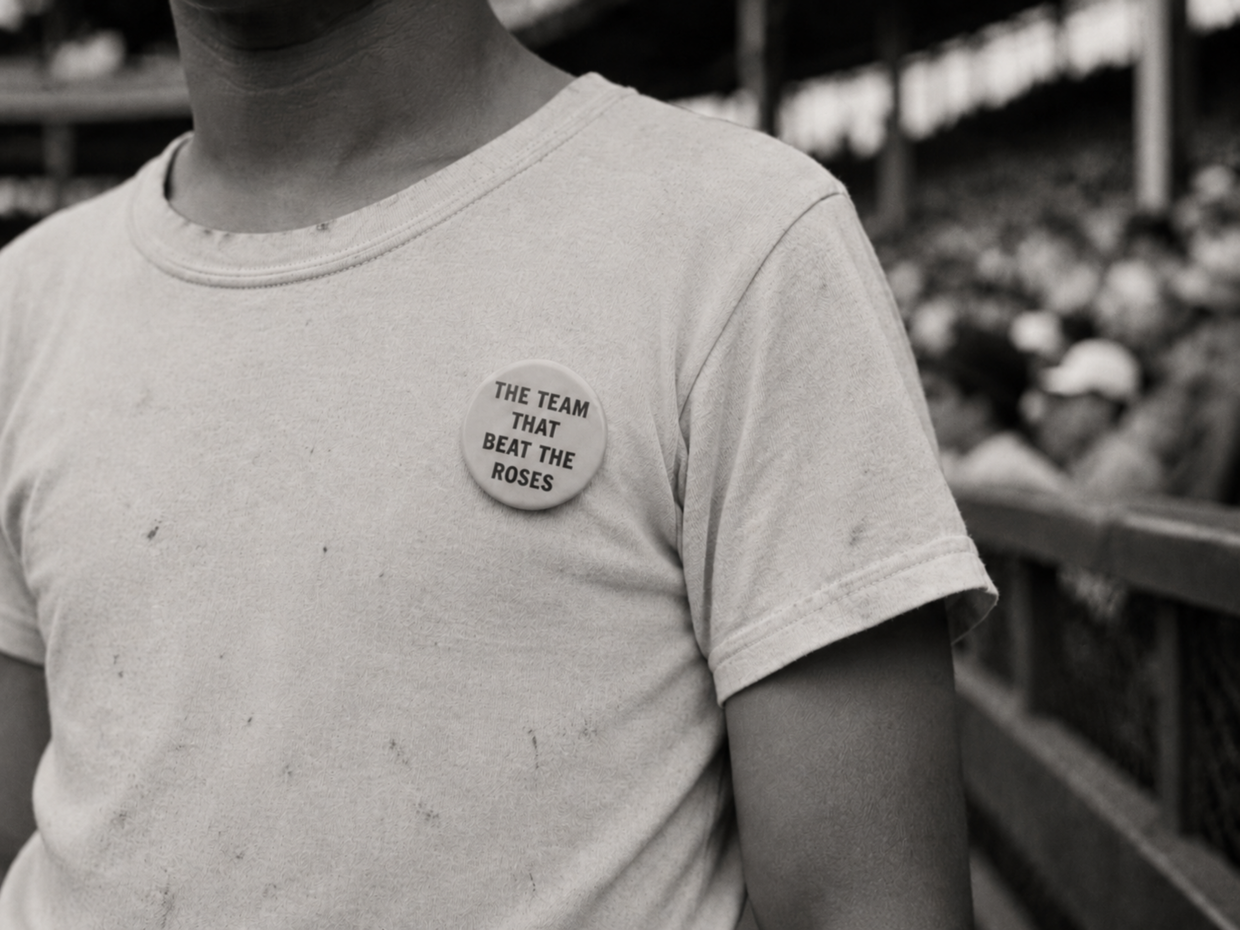 Close-up black-and-white photograph of a young Davenport fan wearing a button that reads “The Team That Beat the Roses.”