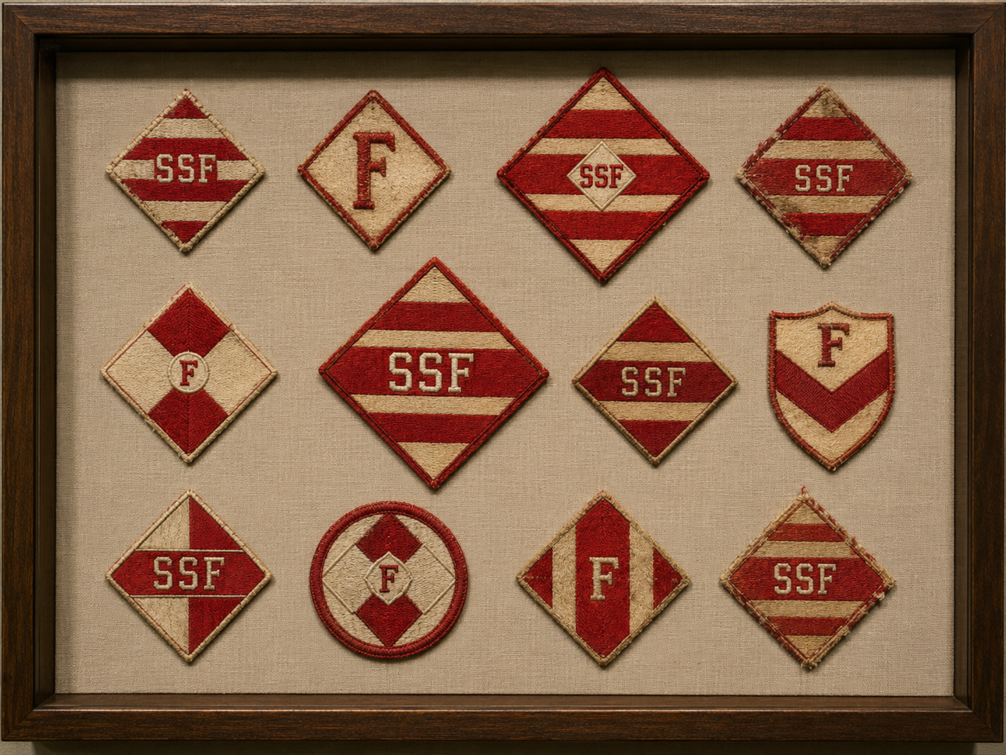 Twelve preserved red-and-cream Fascinators player and employee sleeve patches are arranged in a museum case.