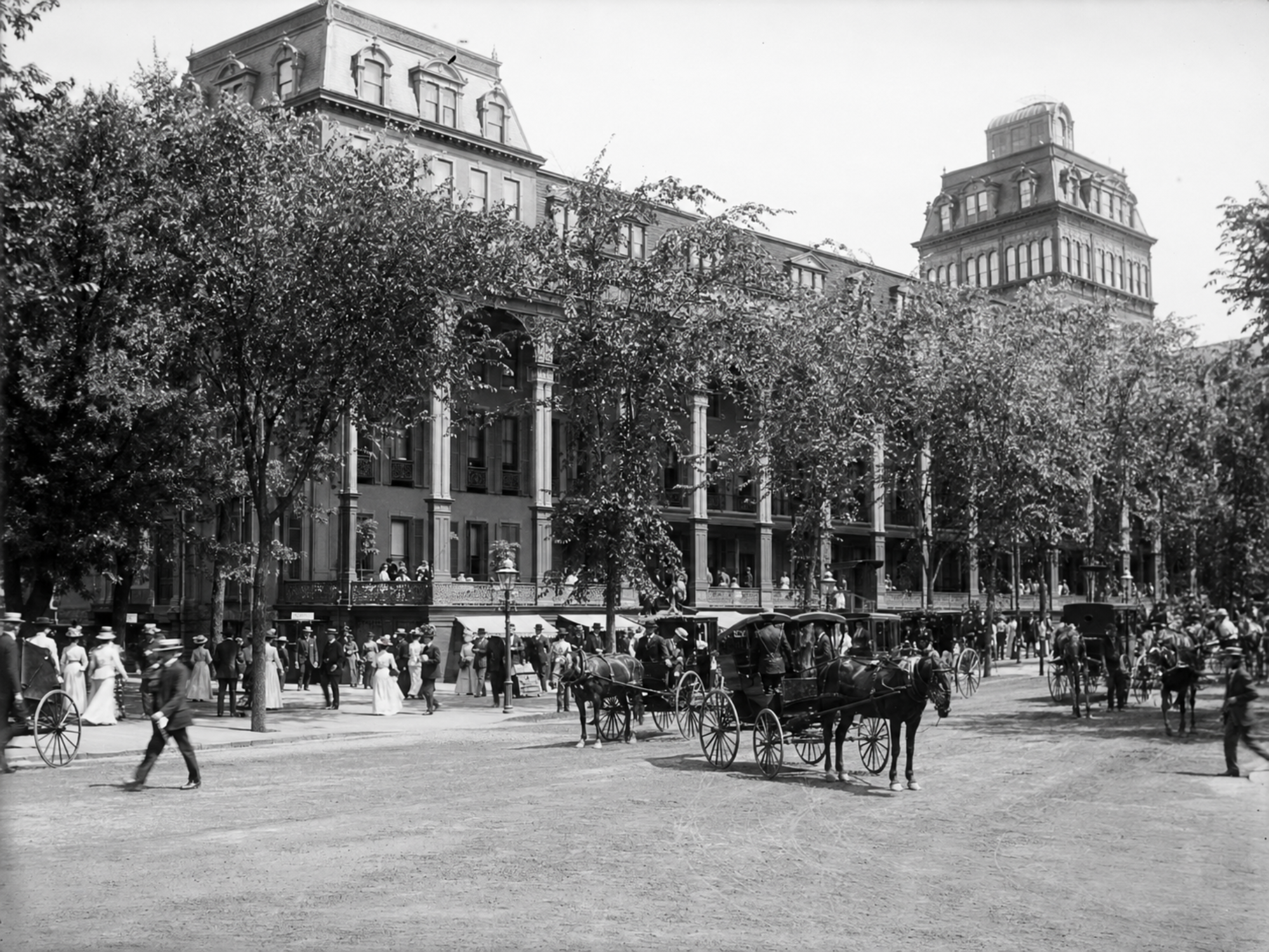 Summer guests and horse-drawn carriages outside Saratoga’s Grand Union Hotel around 1898.