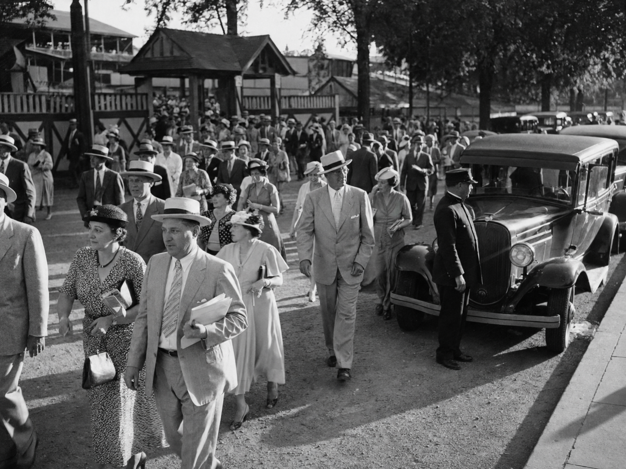 Well-dressed racegoers leaving Saratoga Race Course for waiting automobiles in 1935.