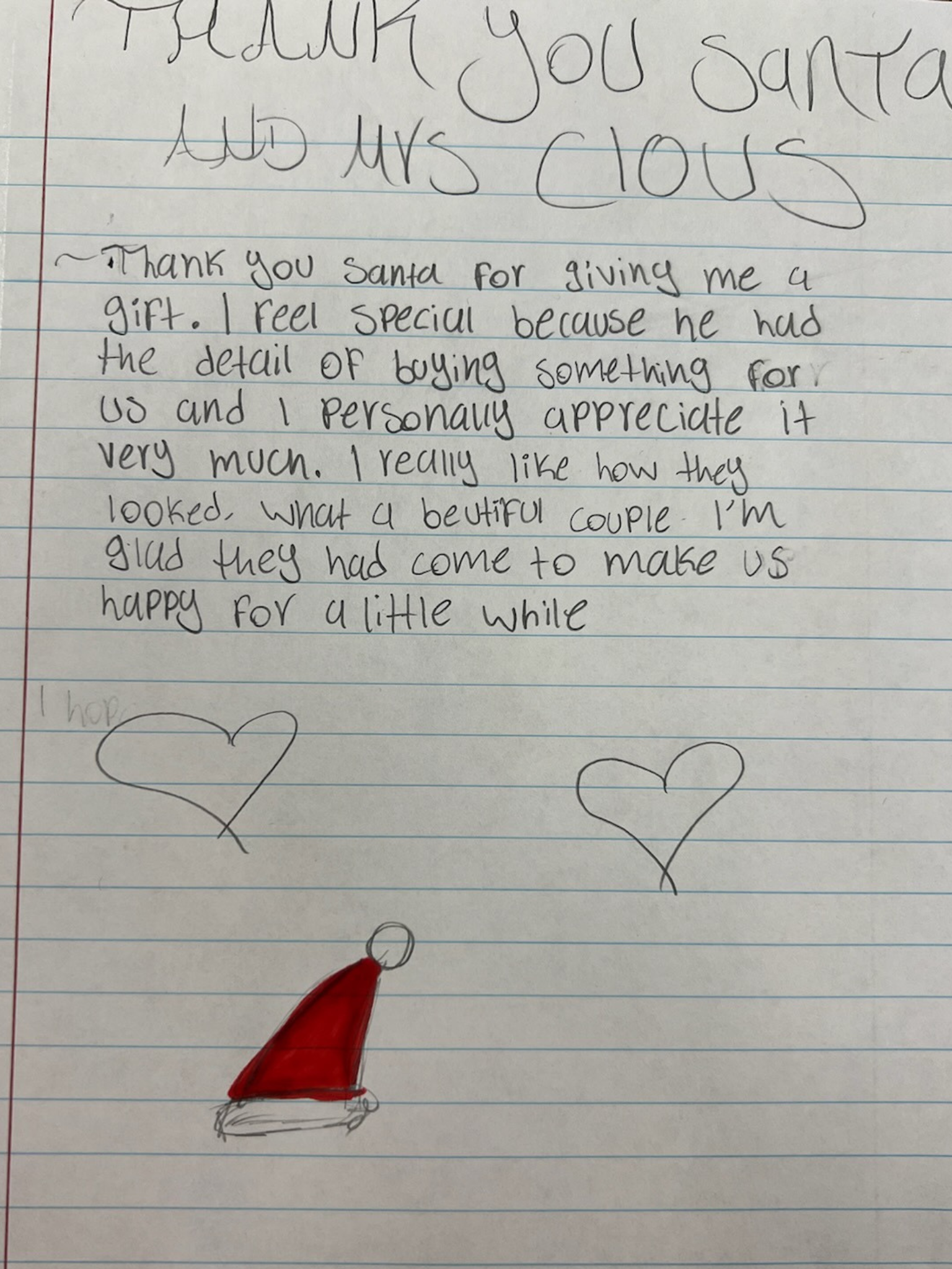 A handwritten note on lined paper with hearts and a drawing of a Santa hat at the bottom. The note expresses gratitude to Santa for a gift.