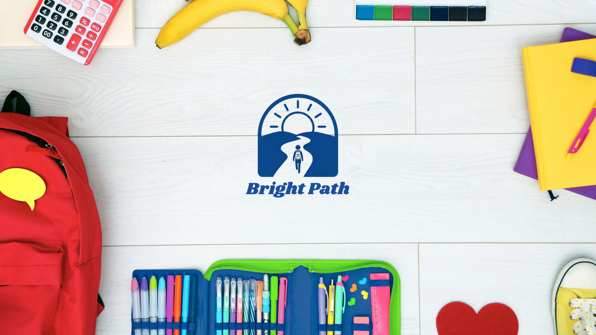 A flat lay of school supplies on a white wooden surface, including a red backpack, colorful pens and markers in a green case, a calculator, notebooks, a banana, and a small colorful cube, with a blue logo and the text 'Bright Path' in the center.