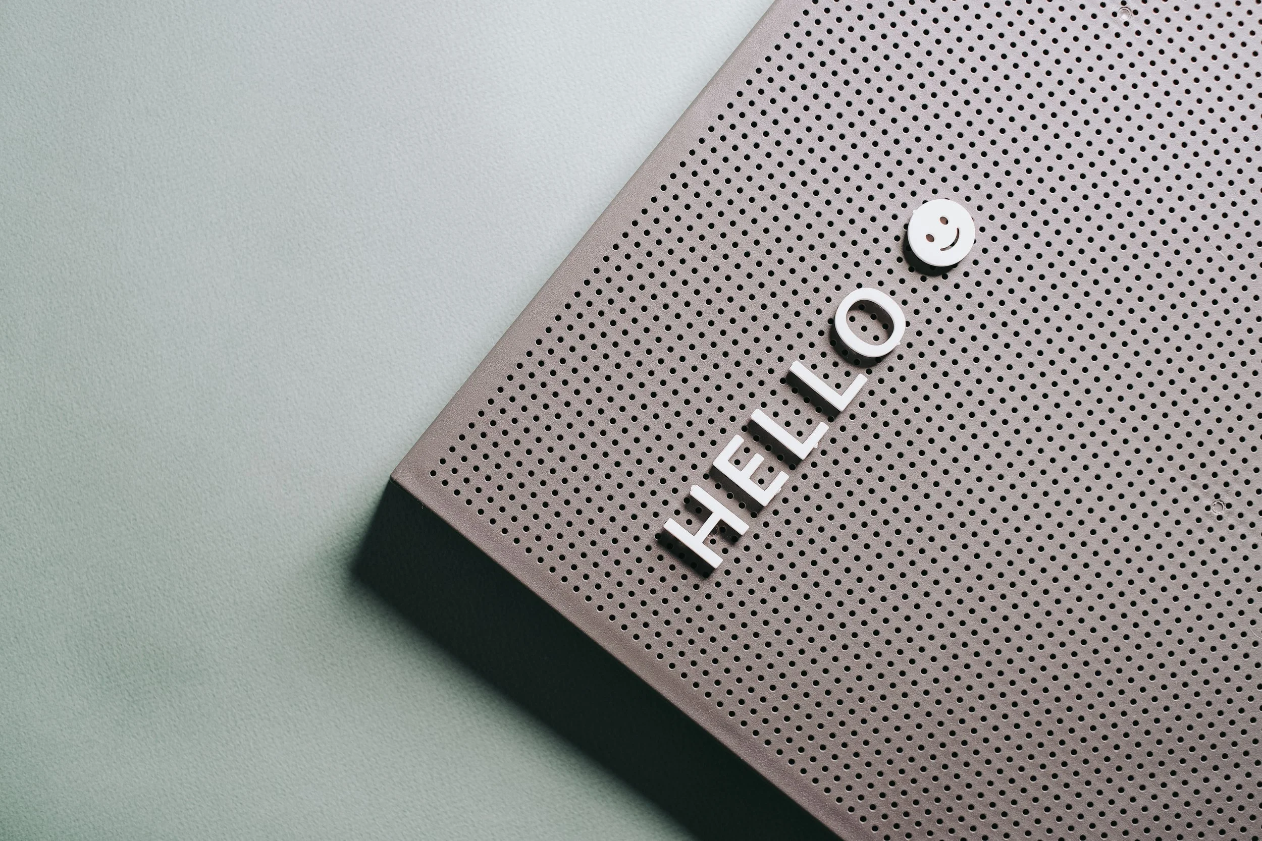 Close-up of a the word "hello" on a light gray surface.