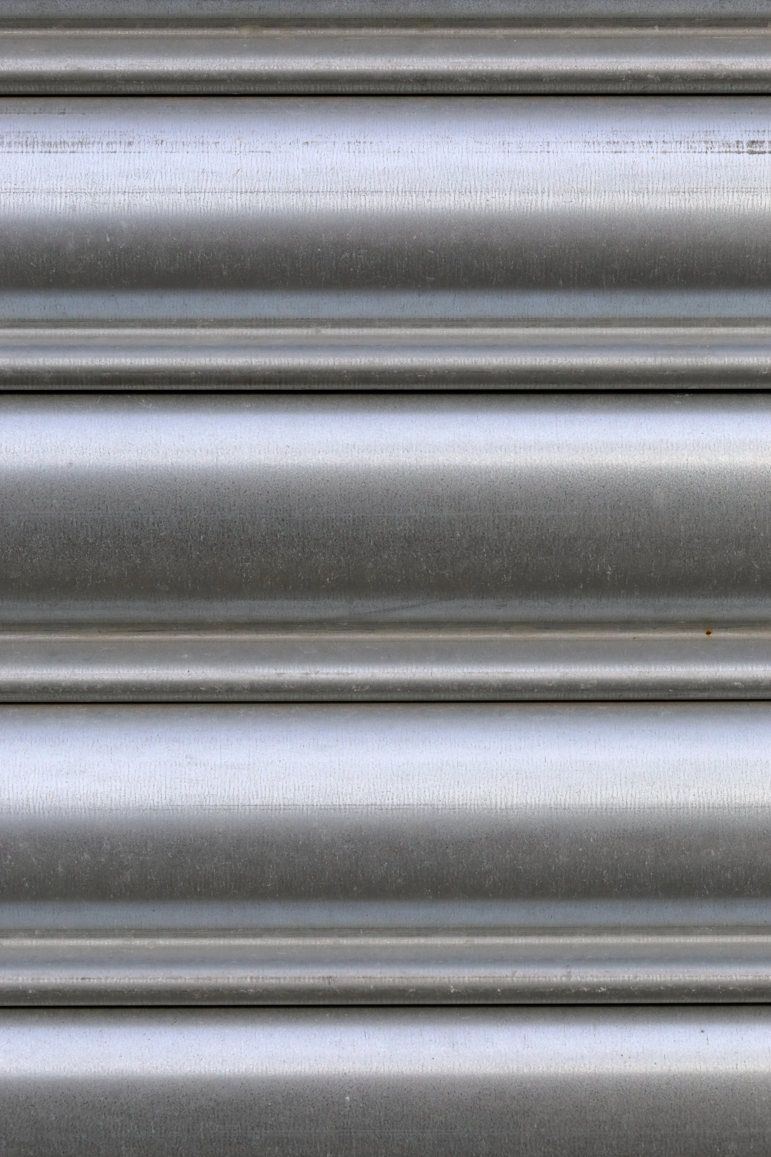 Close-up of metallic, horizontal, ribbed surface with a silver-gray finish.