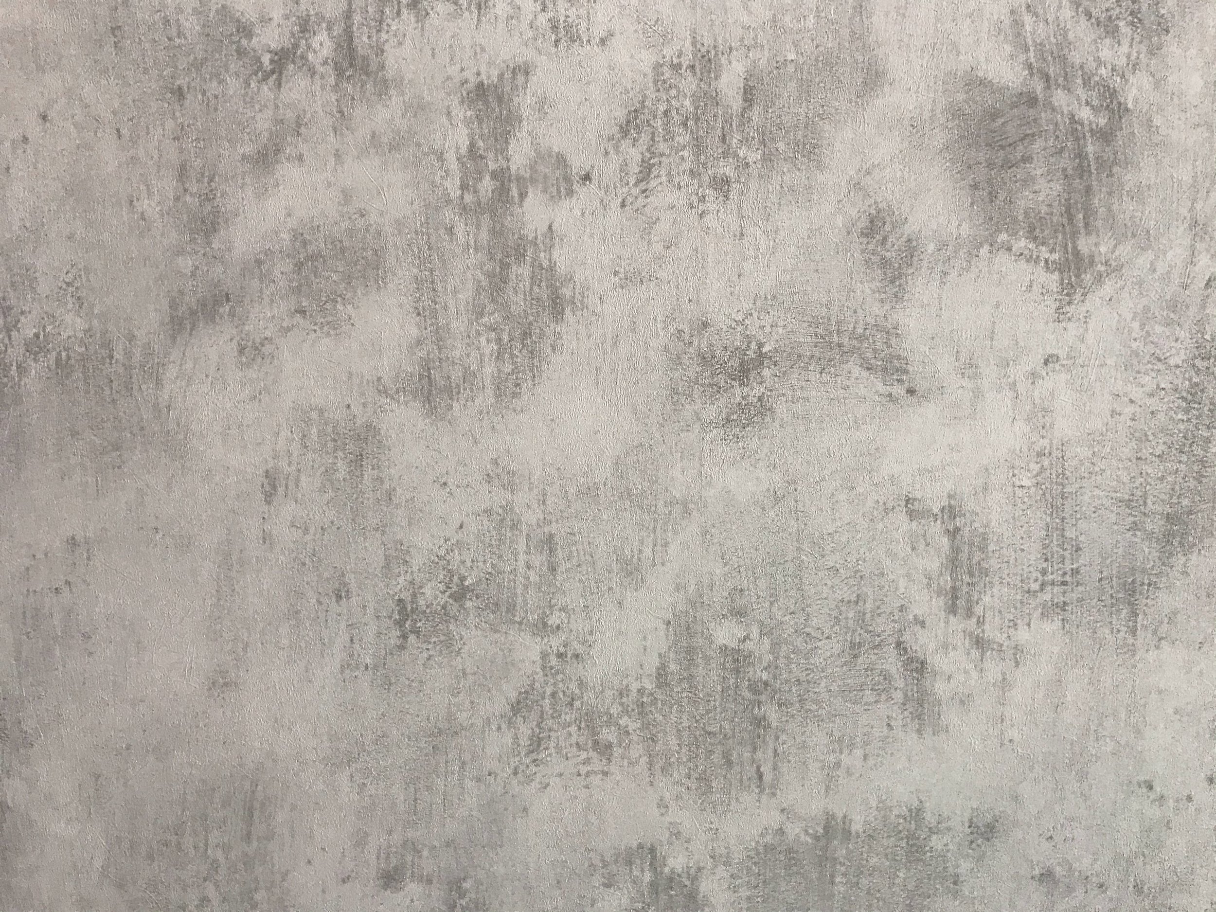A textured concrete wall with gray and beige tones.