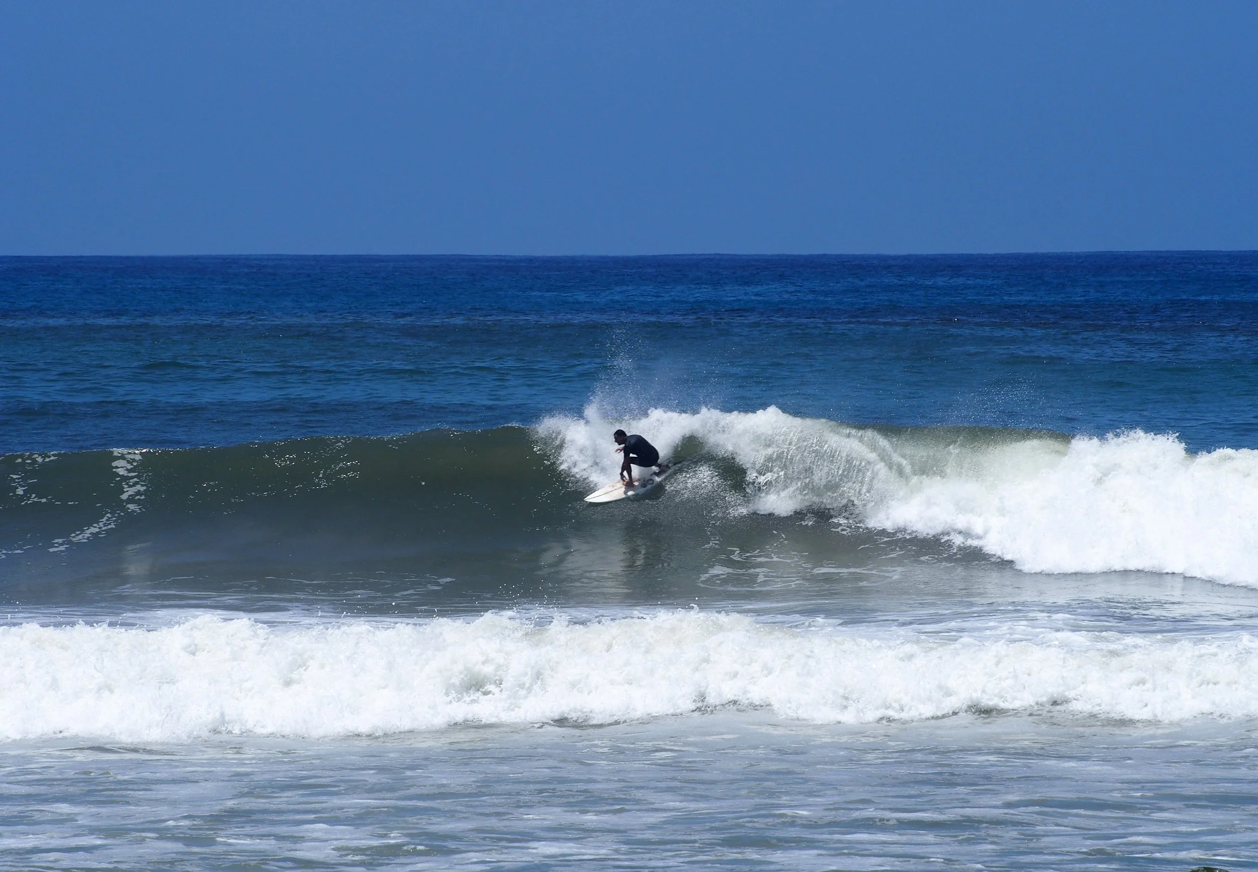 Surfer dropping in on a head high right in Playa Carmen, Costa Rica.