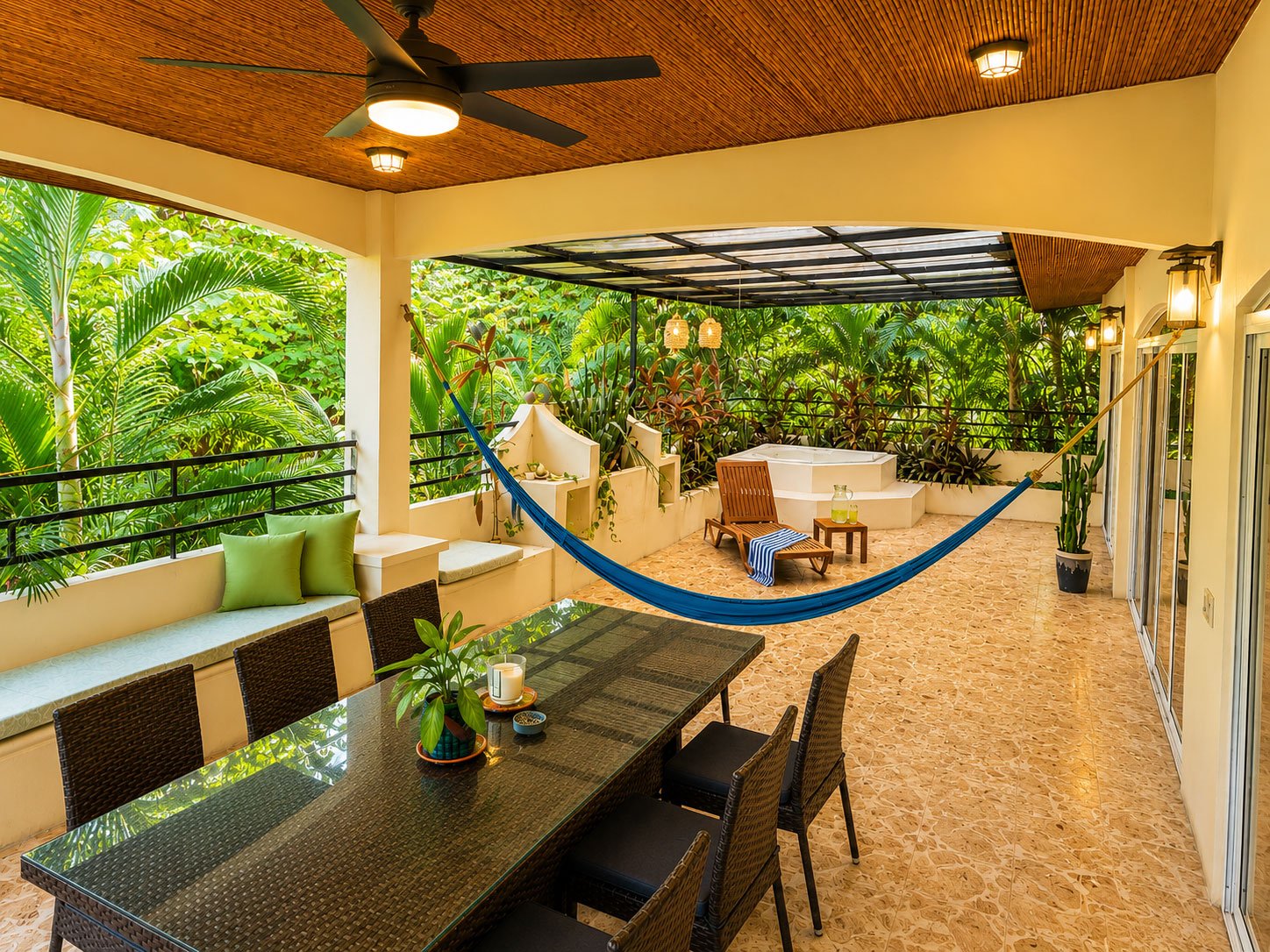 Pacific Penthouse covered balcony with hammock, outdoor dining and tropical garden views in Mal País, Costa Rica.