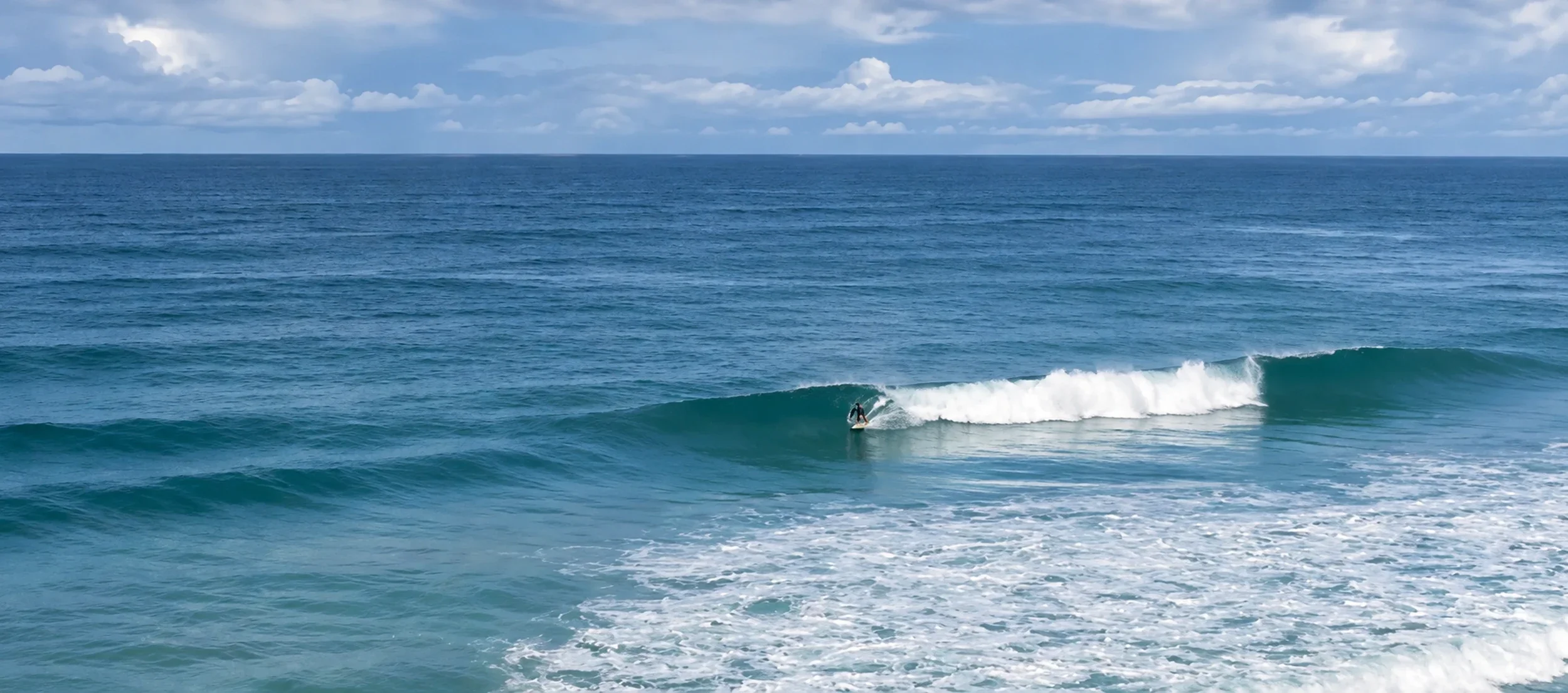 Surfer riding a clean wave at Playa Hermosa in northern Santa Teresa, Costa Rica.