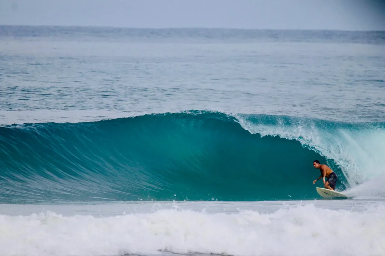 A man surfing on a wave in the ocean.