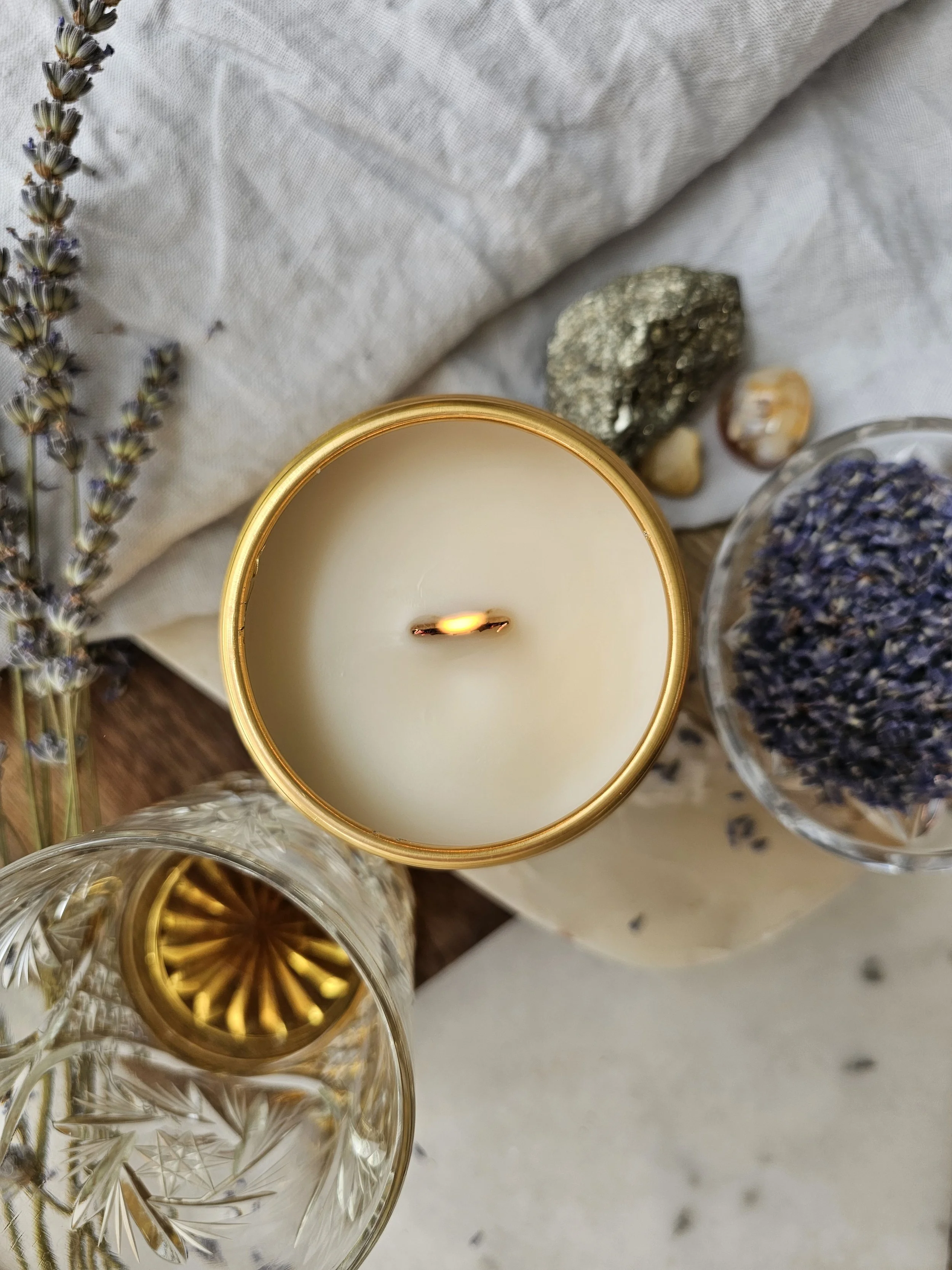 Belle Terre Lavender lit beeswax candle with dried lavender and glass of bourbon