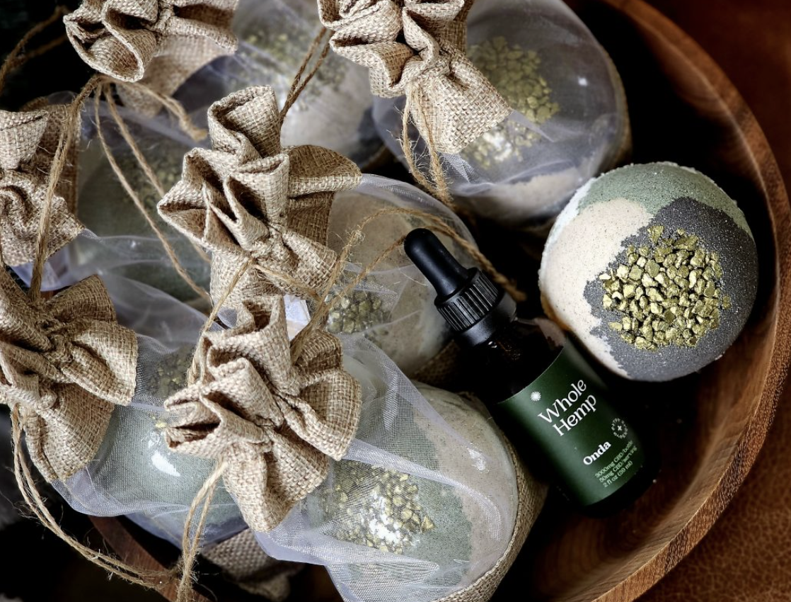 Belle Terre Lavender Mud Balls wrapped in burlap bundles next to Whole Hemp dropper bottle