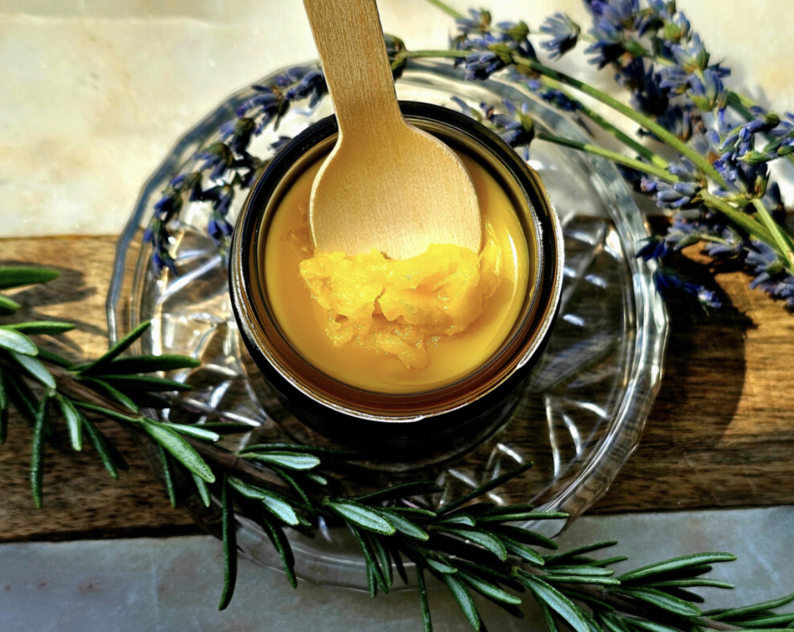Belle Terre Lavender Healing Balm scooped from jar with rosemary