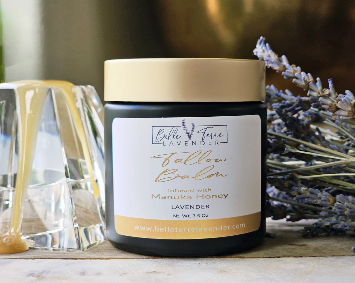 Belle Terre Lavender Tallow Balm scooped from jar with dried lavender and honey