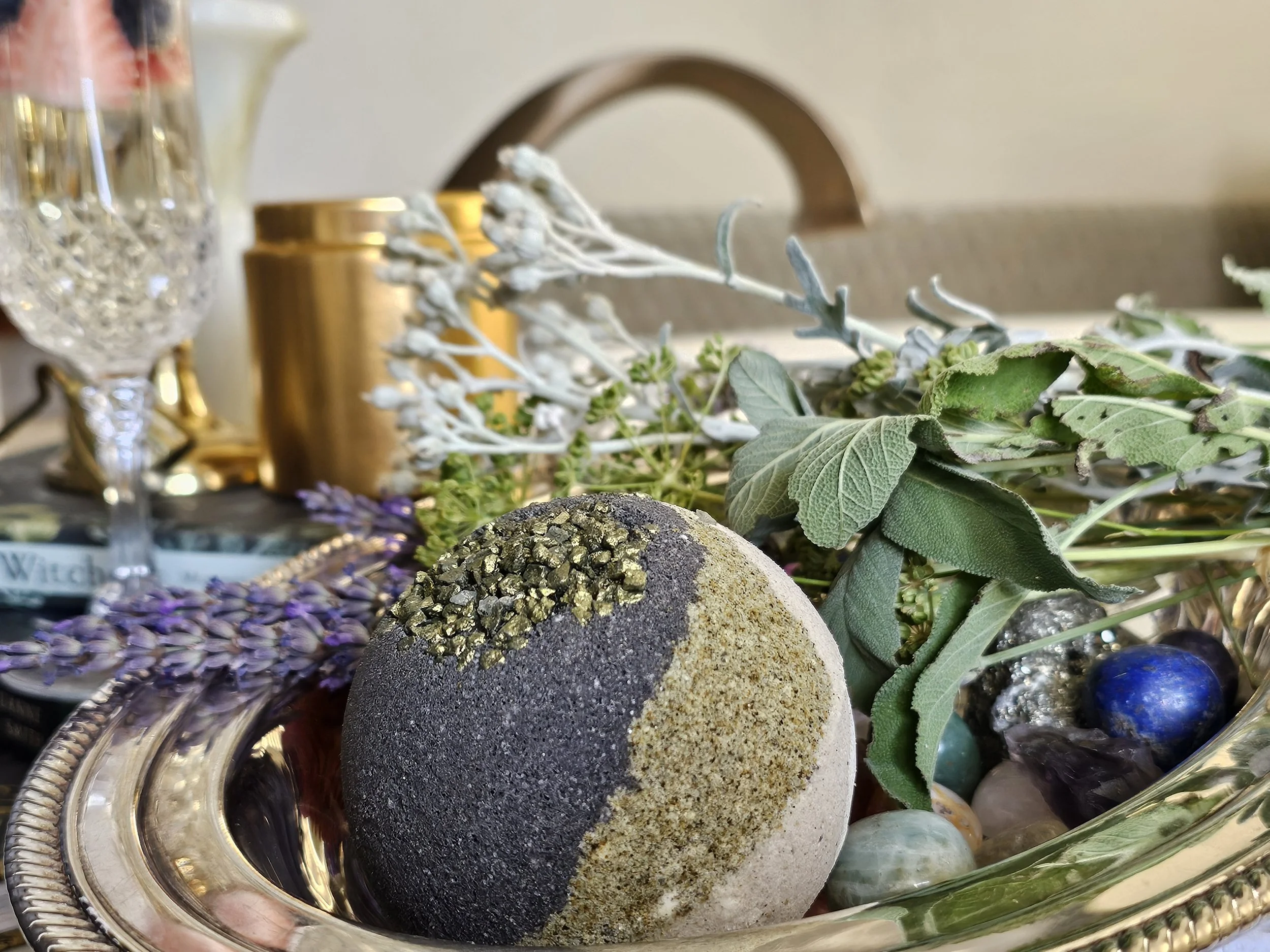 Belle Terre Lavender Mud Ball with mineral crystals and dried herbs next to bathtub