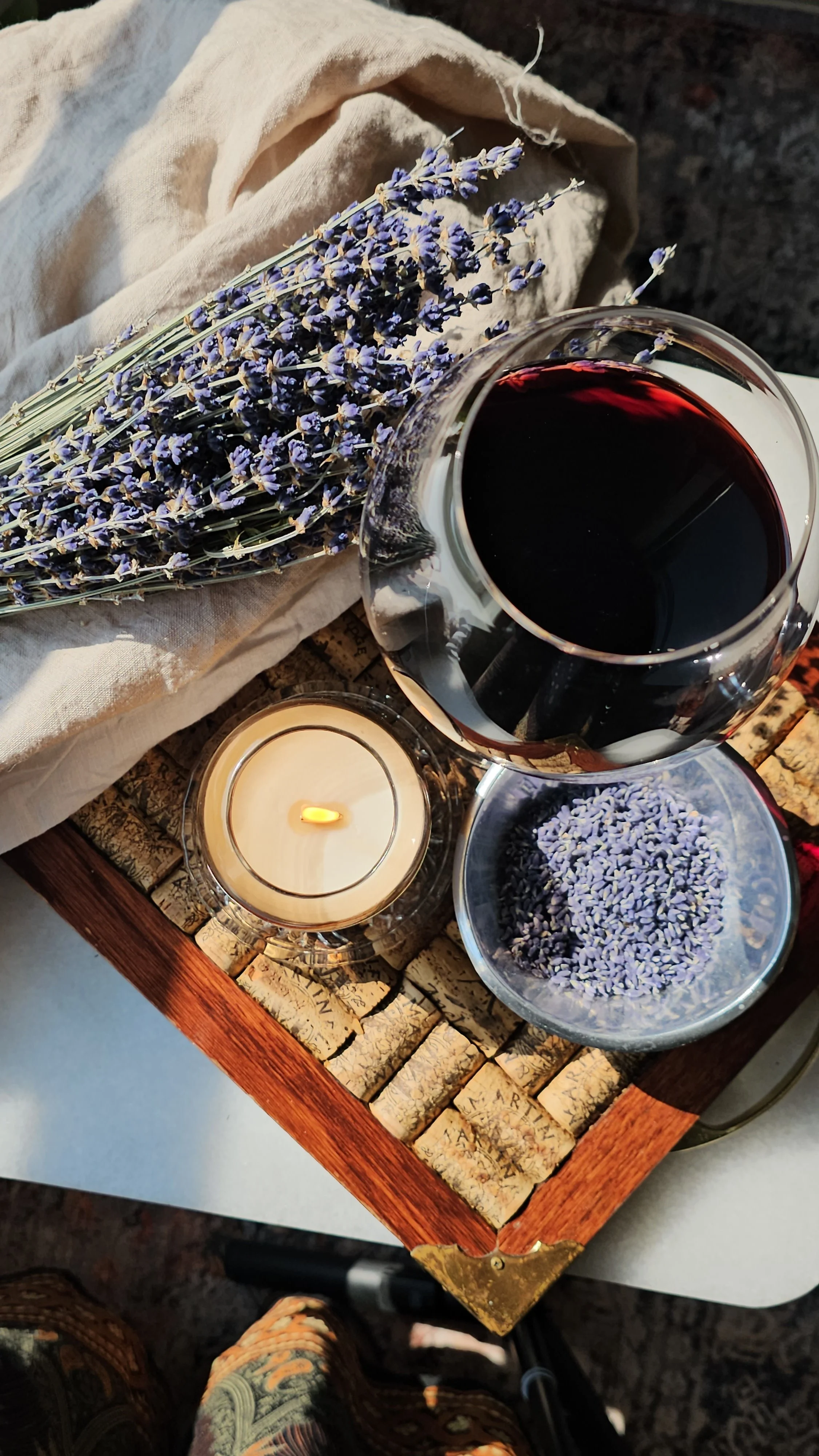 Belle Terre Lavender candle lit beside red wine on cork tray